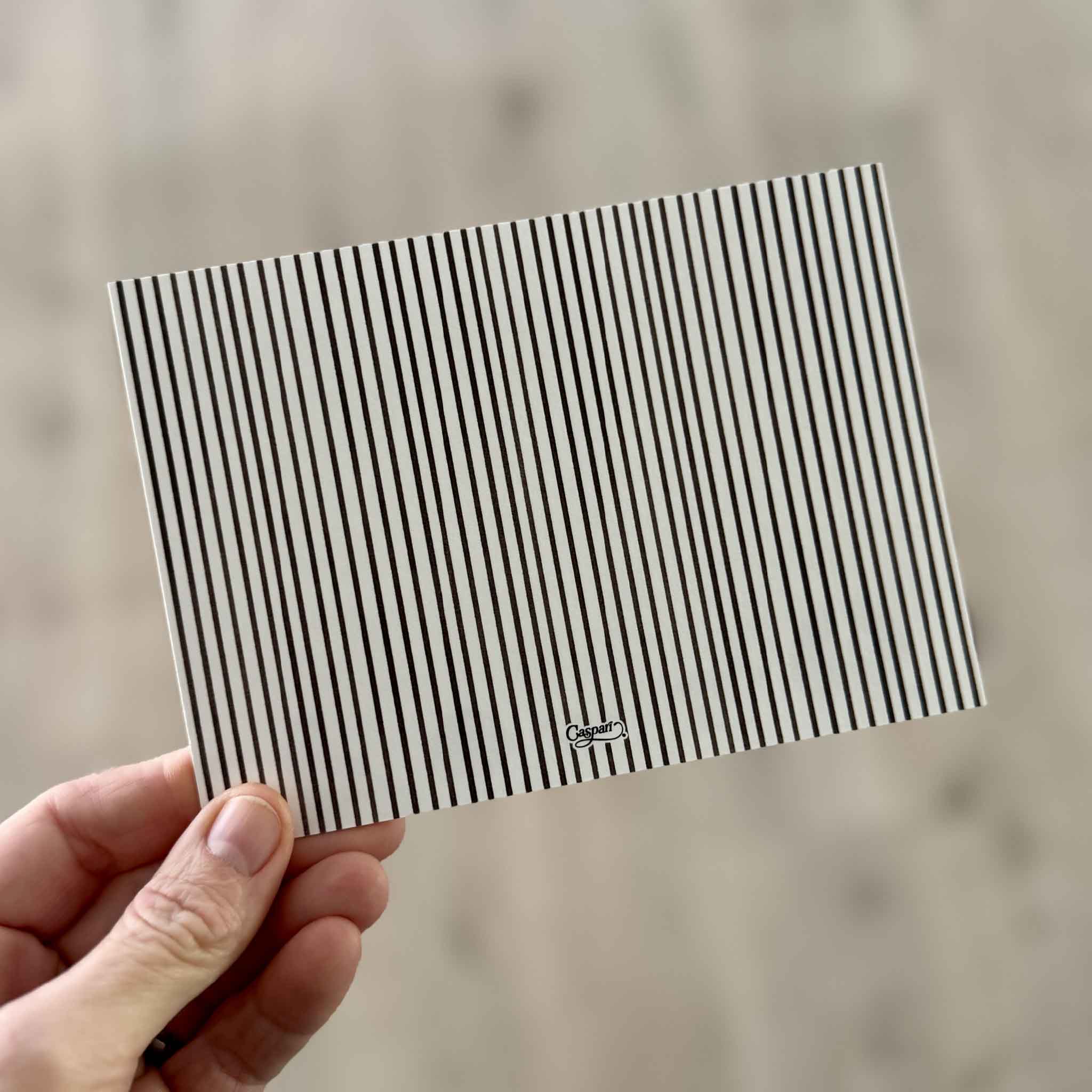 Reverse side of a Doggies flat correspondence card by Caspari featuring Bob Bowdige artwork. The heavyweight, non-folded card has a decorative striped back with ample writing space and is part of a boxed stationery set available at Gray Man Gallery in Pawleys Island, South Carolina.