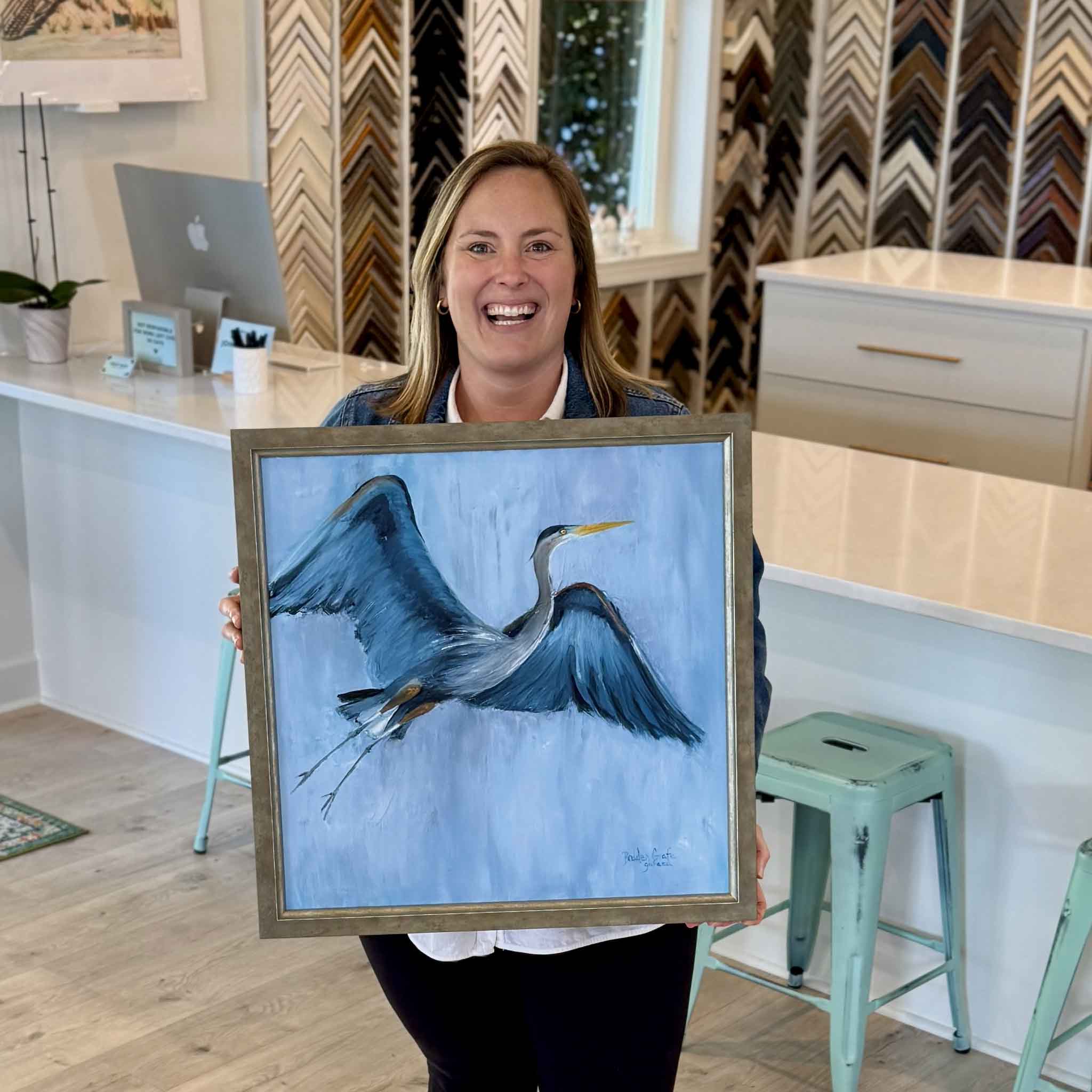 Local artist Braden Grafe Got the Blues heron oil painting shown in Gray Man Gallery in Pawleys Island, framed artwork with expressive brushwork capturing a blue heron in motion in a cool toned coastal palette
