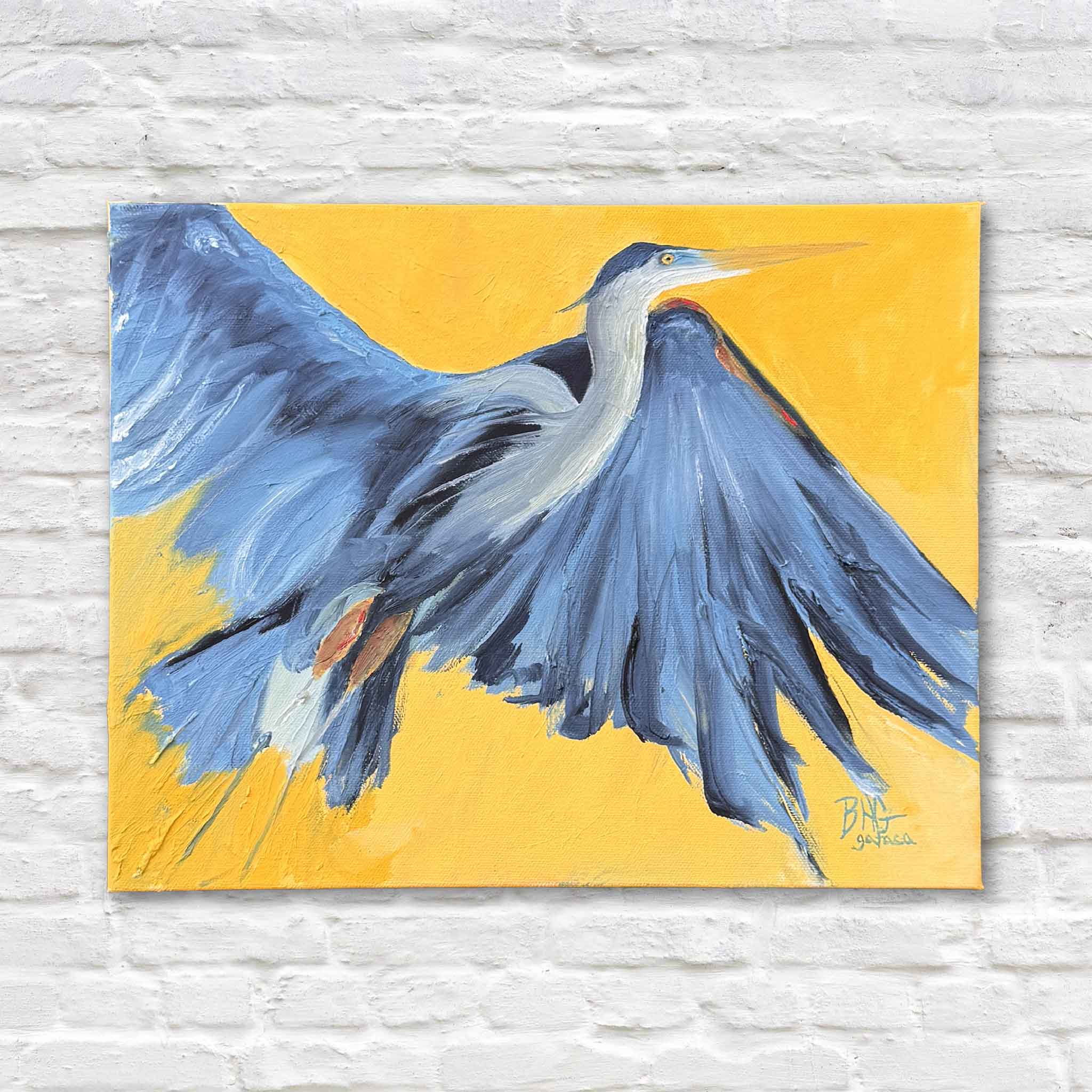 Braden Grafe original oil painting Sunshine featuring a great blue heron in flight with sweeping blue brushstrokes against a bold golden yellow background, gallery wrapped canvas artwork at Gray Man Gallery in Pawleys Island showcasing contemporary Lowcountry coastal art