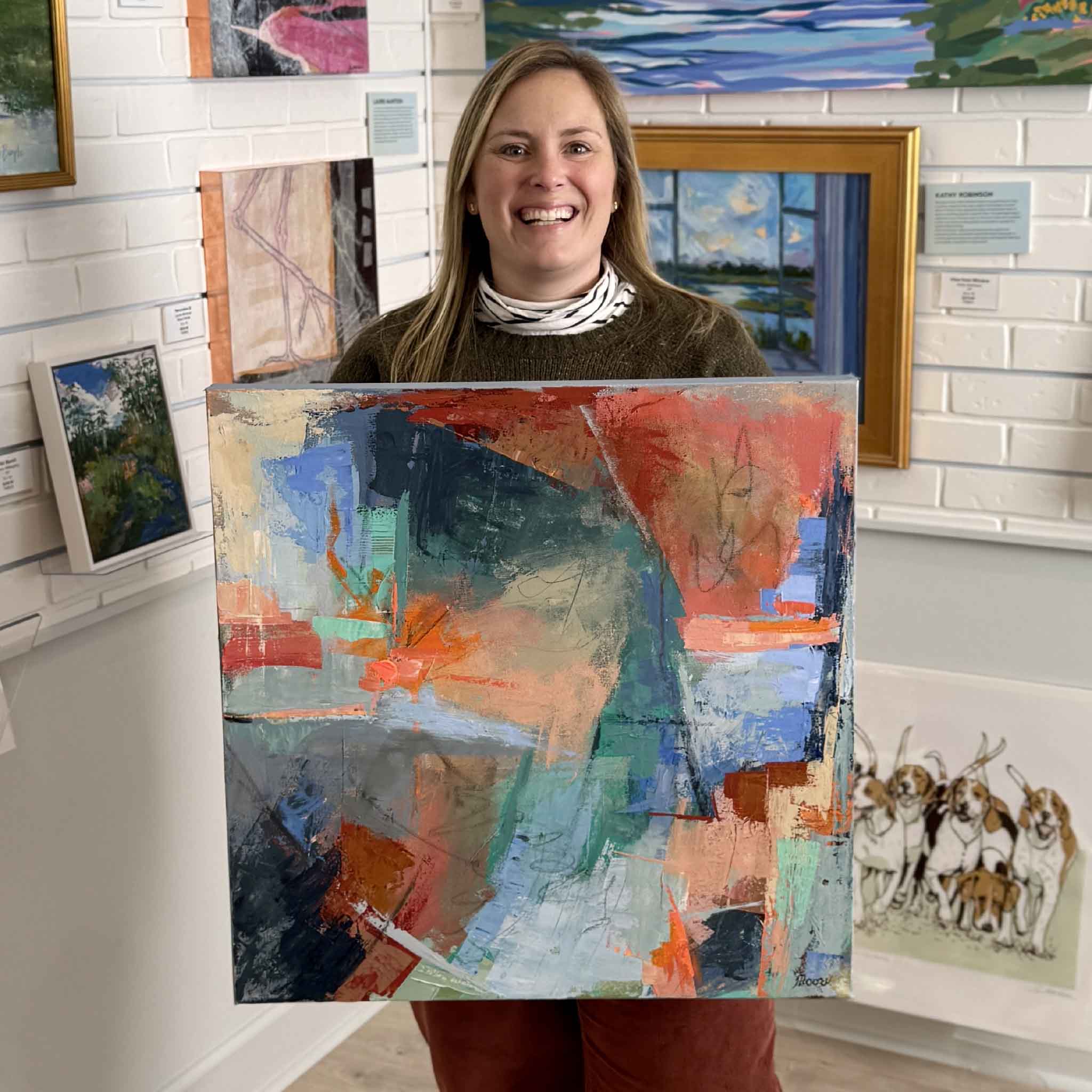 Bordy holding the original abstract acrylic painting Caribbean Splash by Susan Moore inside Gray Man Gallery in Pawleys Island, showing scale, color, and contemporary coastal artwork