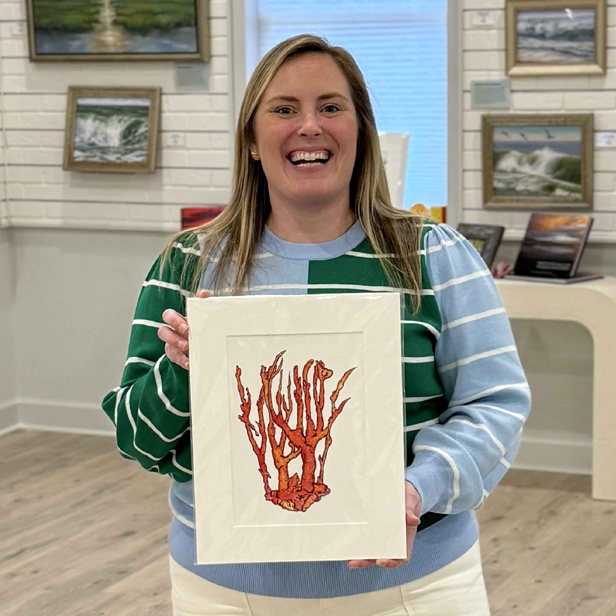Bordy holding Coral Study by local artist Jeanne O’Neal, fine art giclée print matted to fit standard 11x14 frame at Gray Man Gallery in Pawleys Island South Carolina