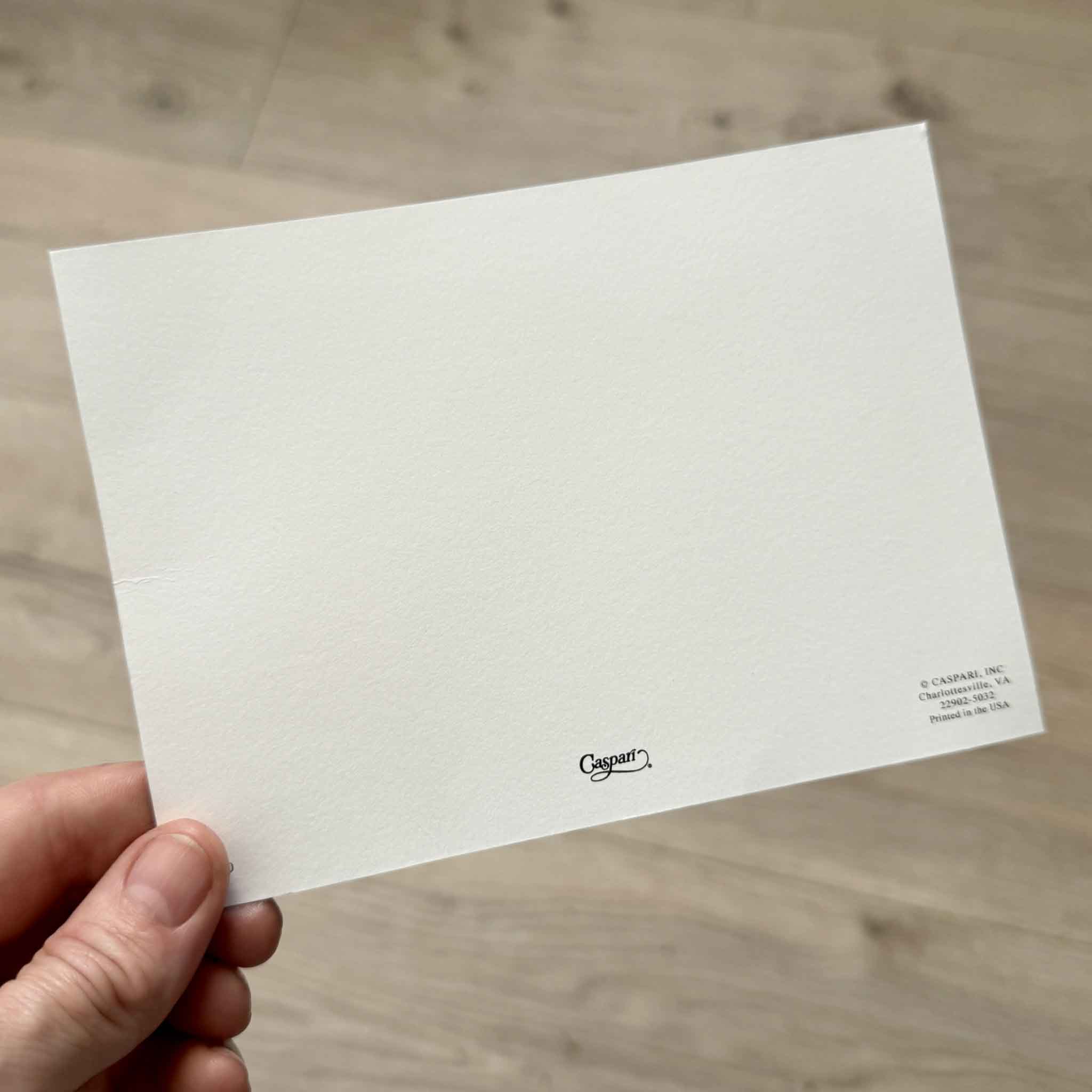 Back of a flat Doggy Paddle correspondence card by Masaki Ryo for Caspari, showing the blank writing surface with Caspari logo. This boxed stationery set includes 12 flat correspondence cards and 12 coordinating envelopes, printed in the USA and available at Gray Man Gallery in Pawleys Island.