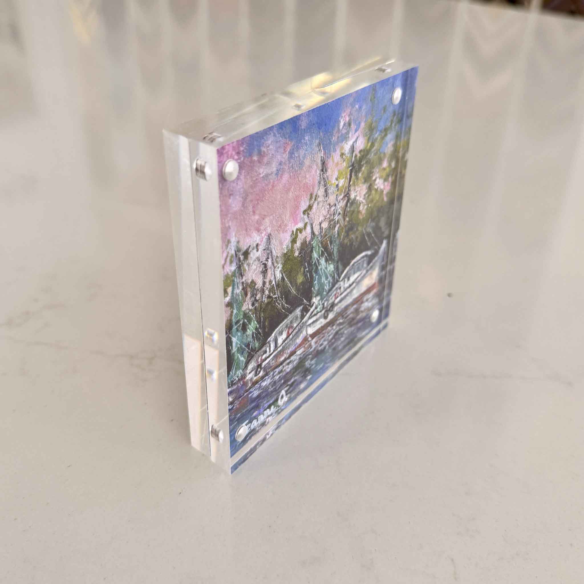 Angled view of “Evening Light,” an acrylic block art print by Jeanne O’Neal, showing the thickness, polished edges, and dimensional quality of the clear acrylic block with coastal boat imagery, photographed at Gray Man Gallery in Pawleys Island, SC