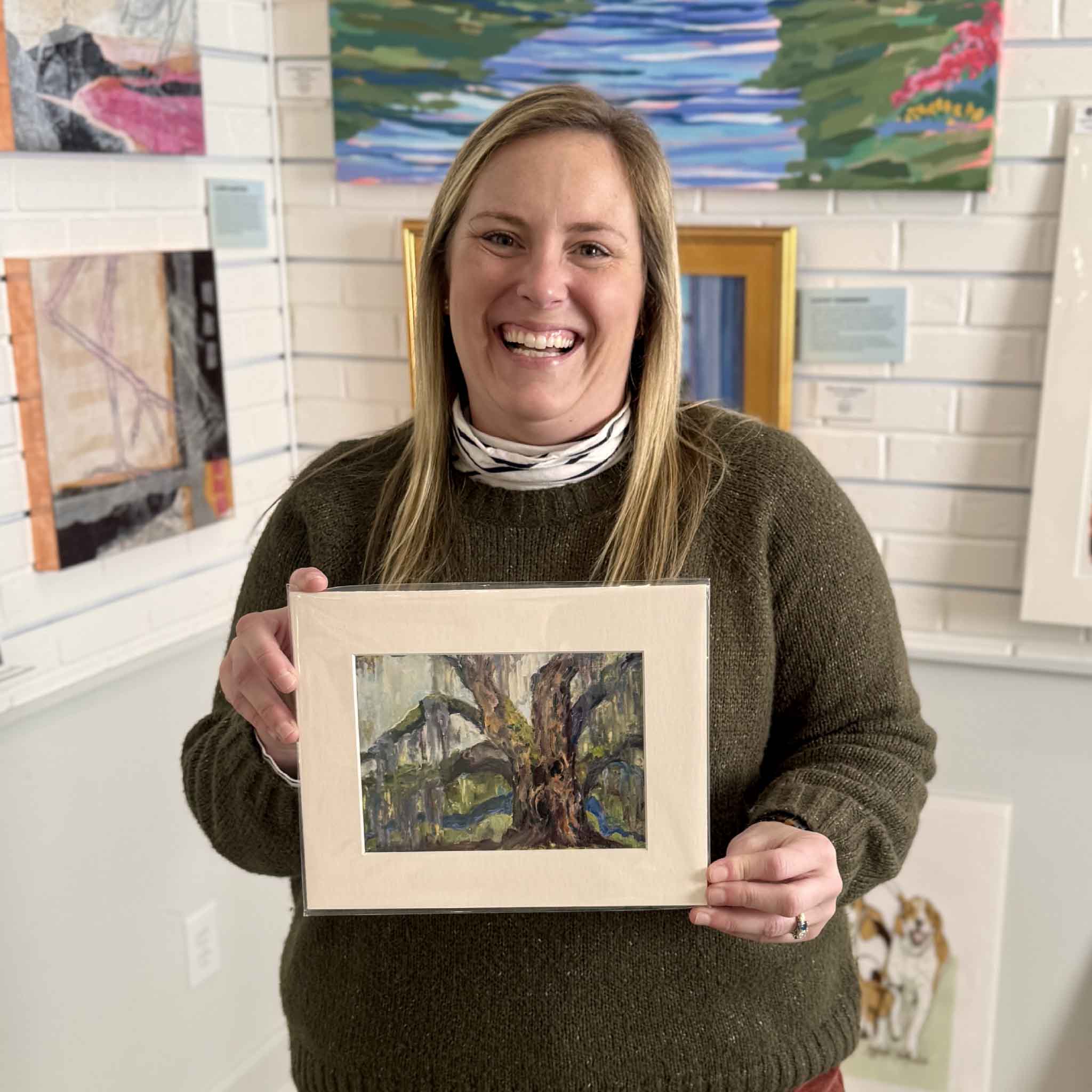 Bordy holding “Graceful Rest” by Jeanne O’Neal, 8x10 matted fine art print ready for standard frames, photographed inside Gray Man Gallery in Pawleys Island, South Carolina