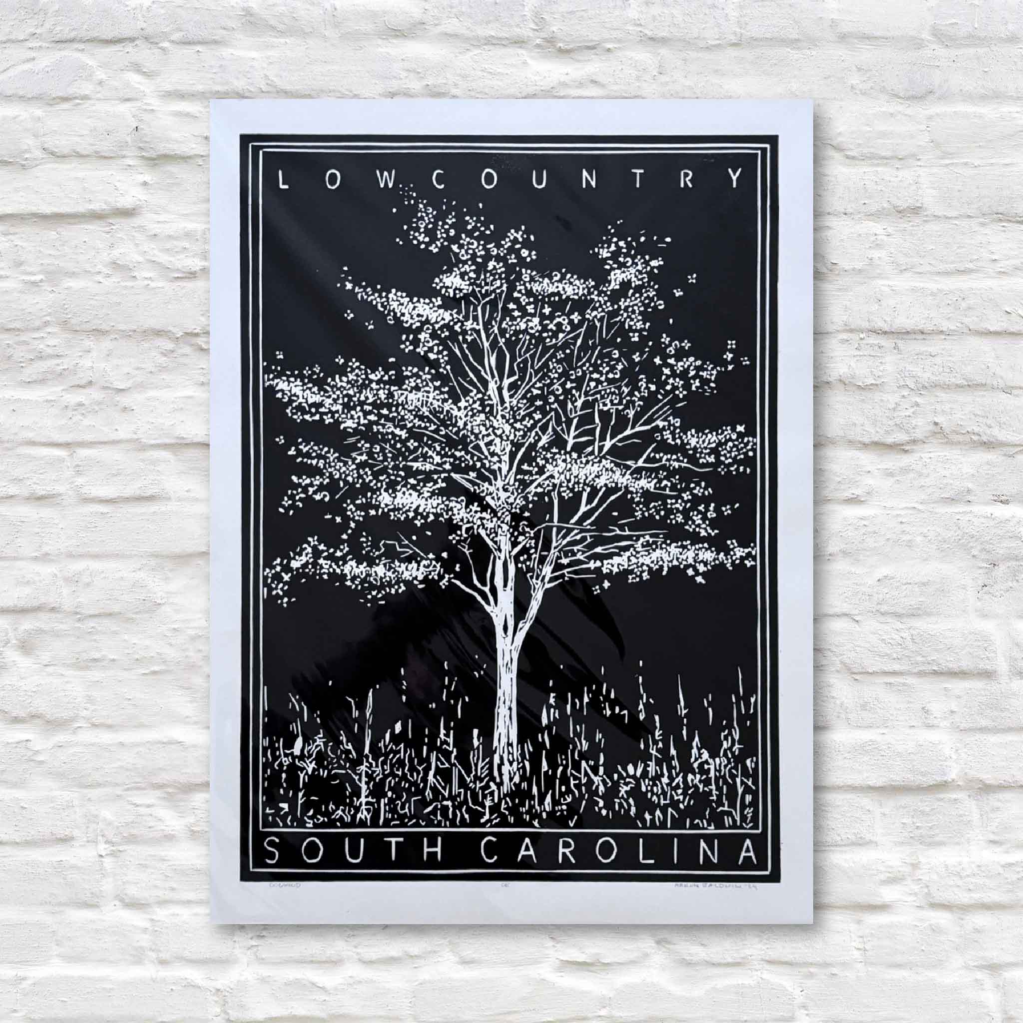 Aaron Baldwin’s Dogwood linocut in black, a striking black-and-white relief print depicting a flowering dogwood tree rooted in the Lowcountry landscape.