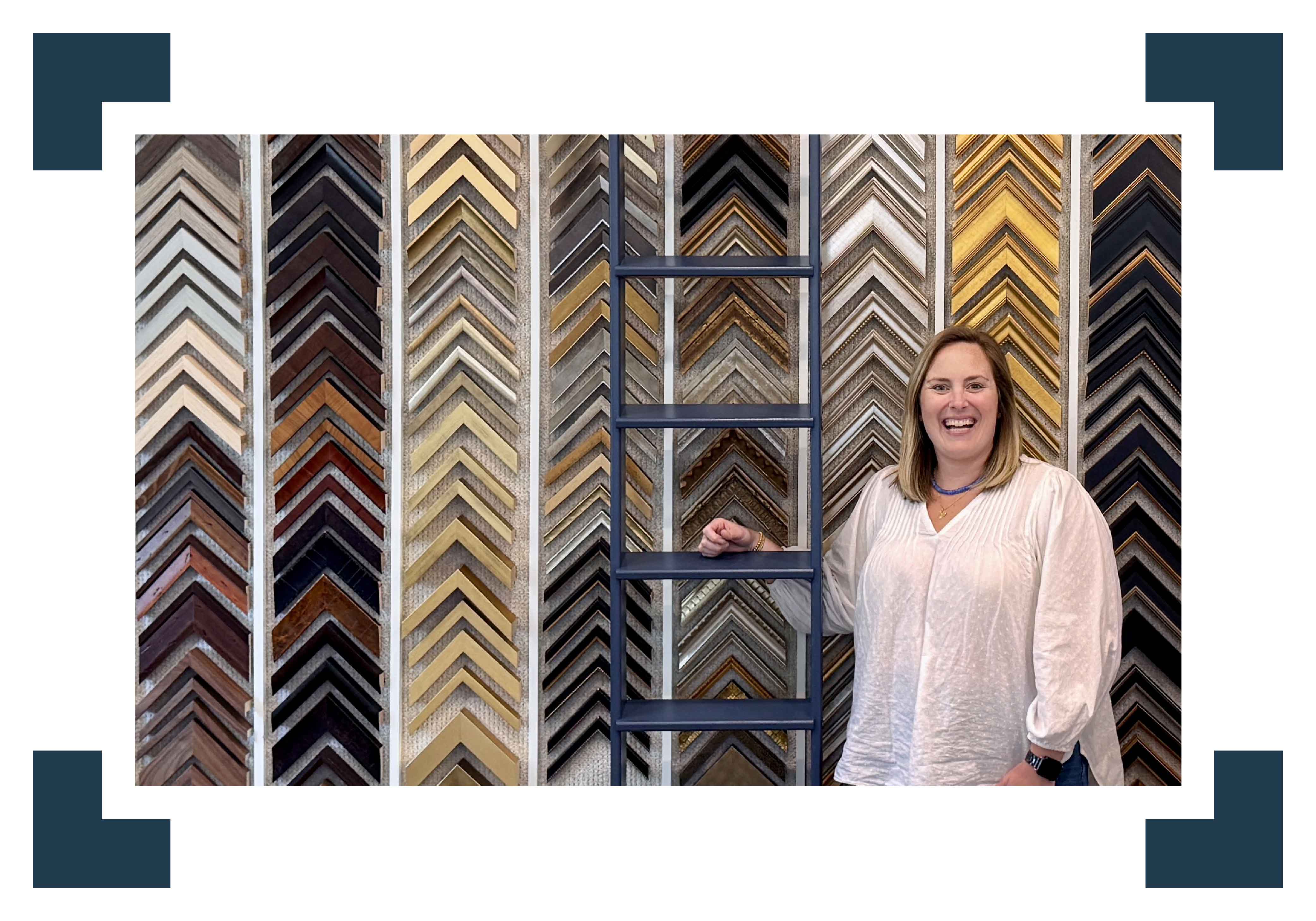 Bordy at Gray Man Gallery’s custom framing studio in Pawleys Island, SC, surrounded by hundreds of frame moulding options, highlighting over 45 years of experience in conservation framing, fine art mounting, textile framing, shadow boxes, and professional presentation of Lowcountry artwork and personal keepsakes