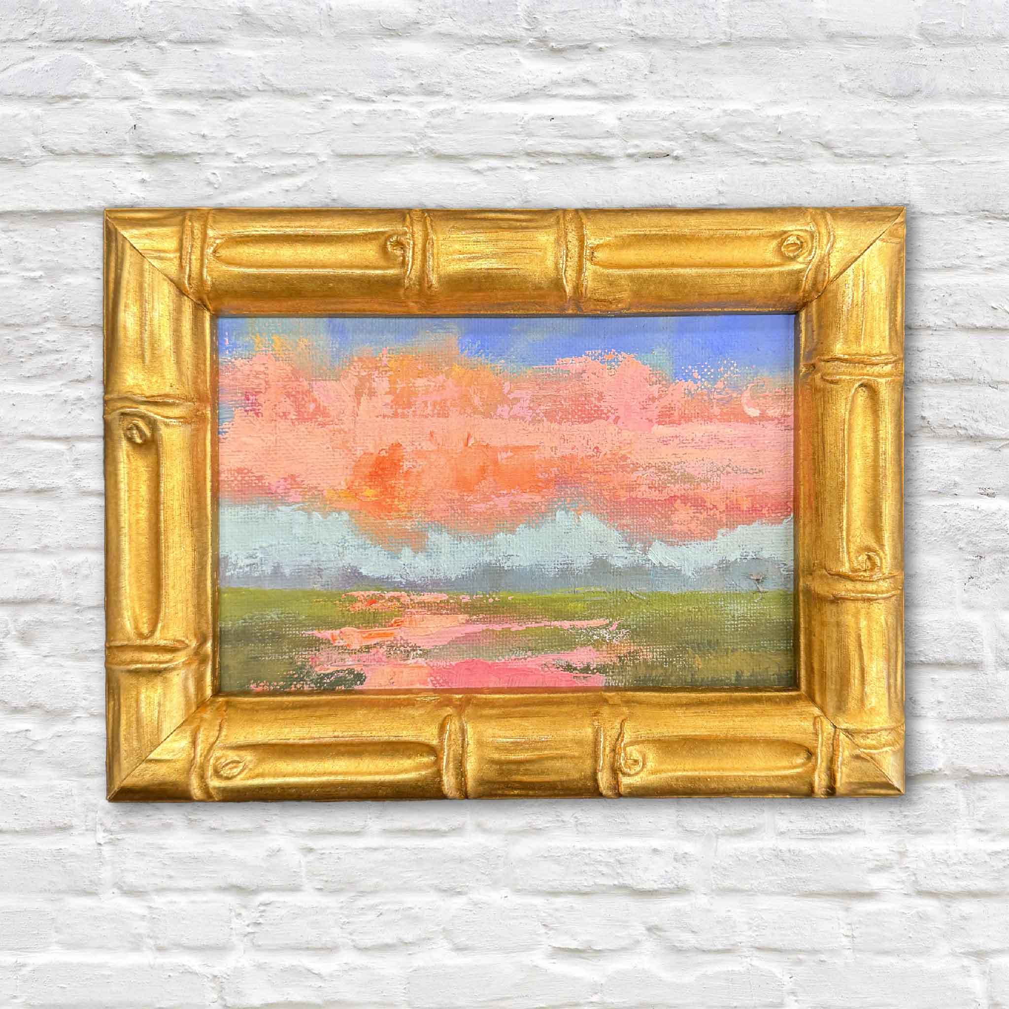 Blush of Day is a small framed original oil painting by Jeanne O’Neal featuring soft blush pink clouds, pale blue sky, and a quiet Lowcountry marsh landscape, shown in a gold bamboo-style frame and sized perfectly for bookshelf or easel display.