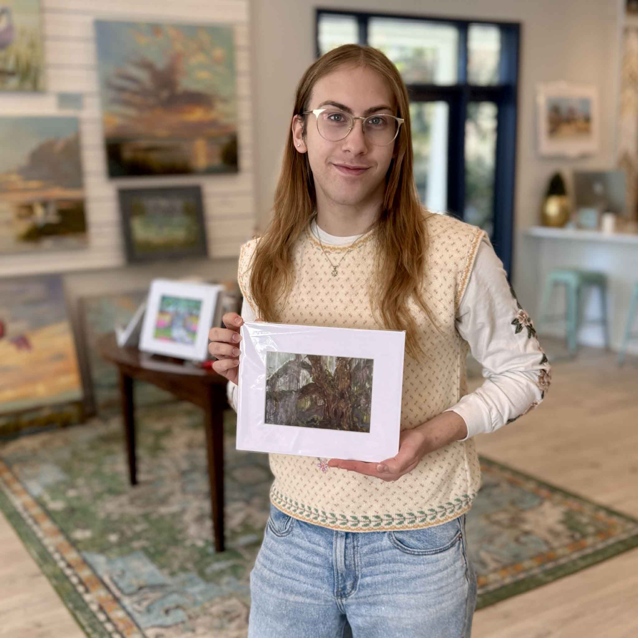 A Gray Man Gallery team member holds the 8x10 matted Honesty giclée by Jeanne O’Neal to show scale inside the gallery.
