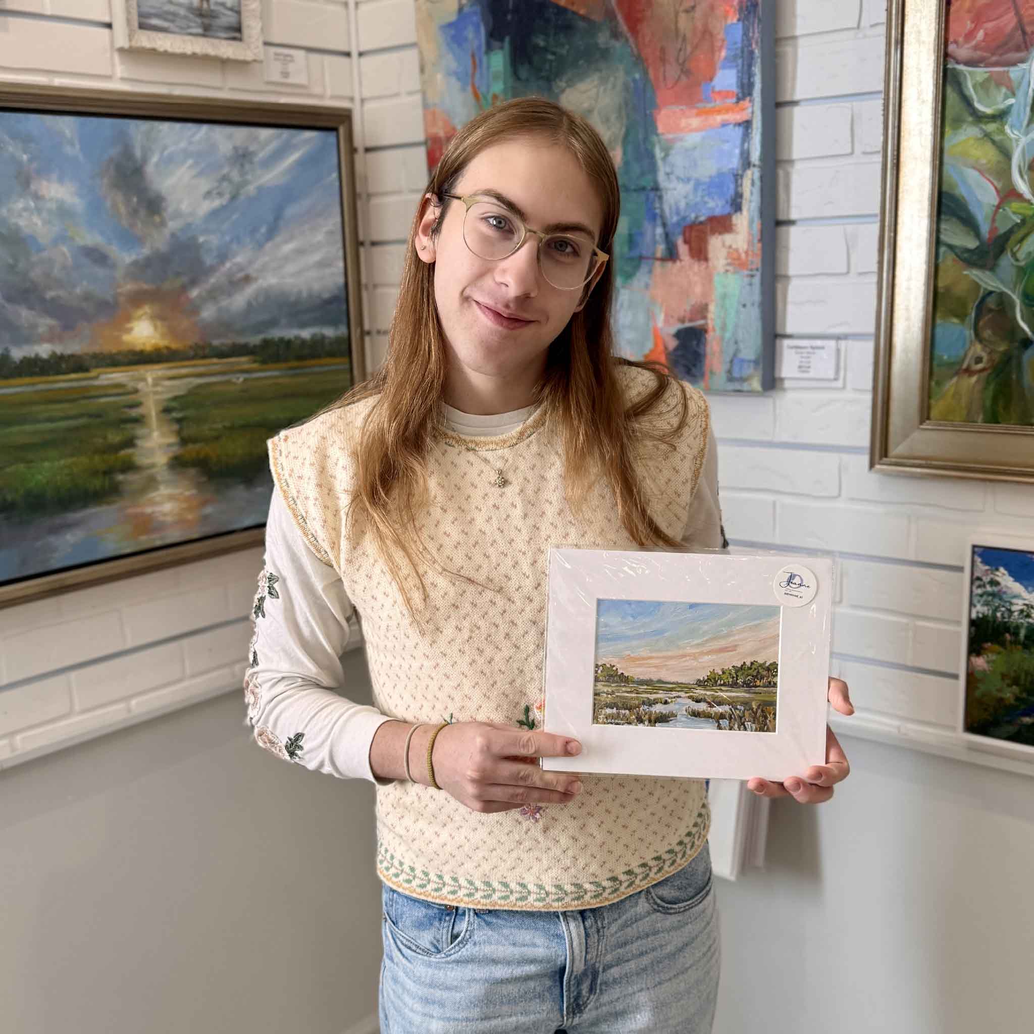 A Gray Man Gallery team member holding the Kisses fine art print by Jeanne O’Neal to show scale and presentation in the gallery.