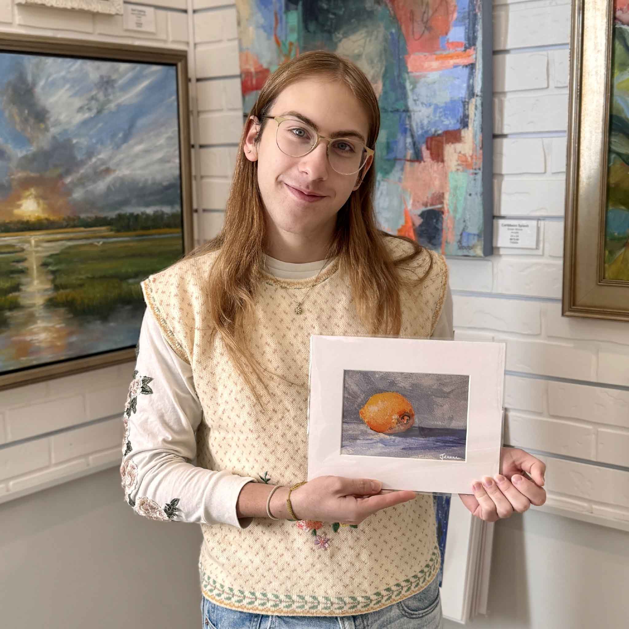A Gray Man Gallery team member holding the Lemon Drop fine art print by Jeanne O’Neal to show scale and presentation.