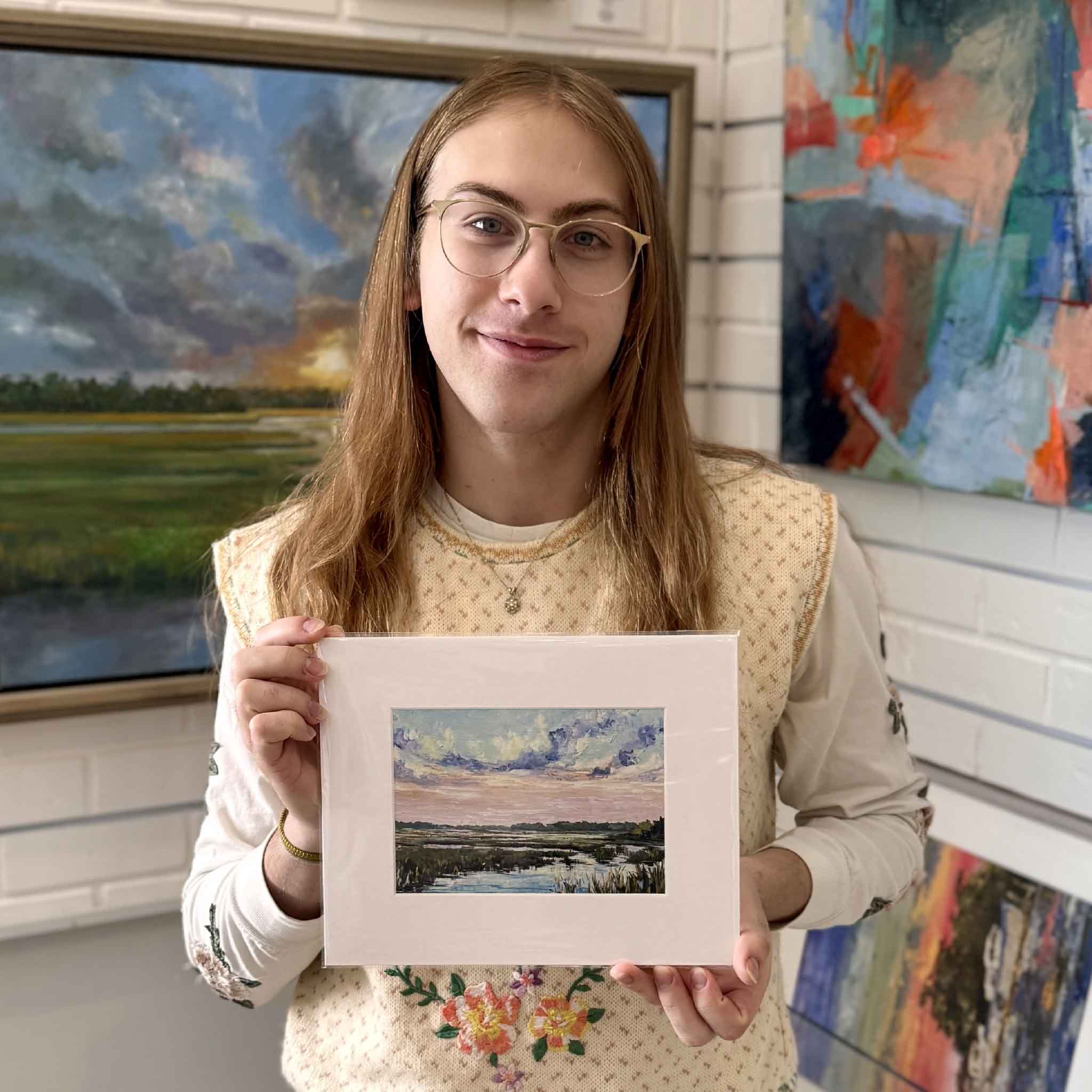 A Gray Man Gallery team member holds the 8x10 matted No Regrets giclée by Jeanne O’Neal to show scale inside the gallery.