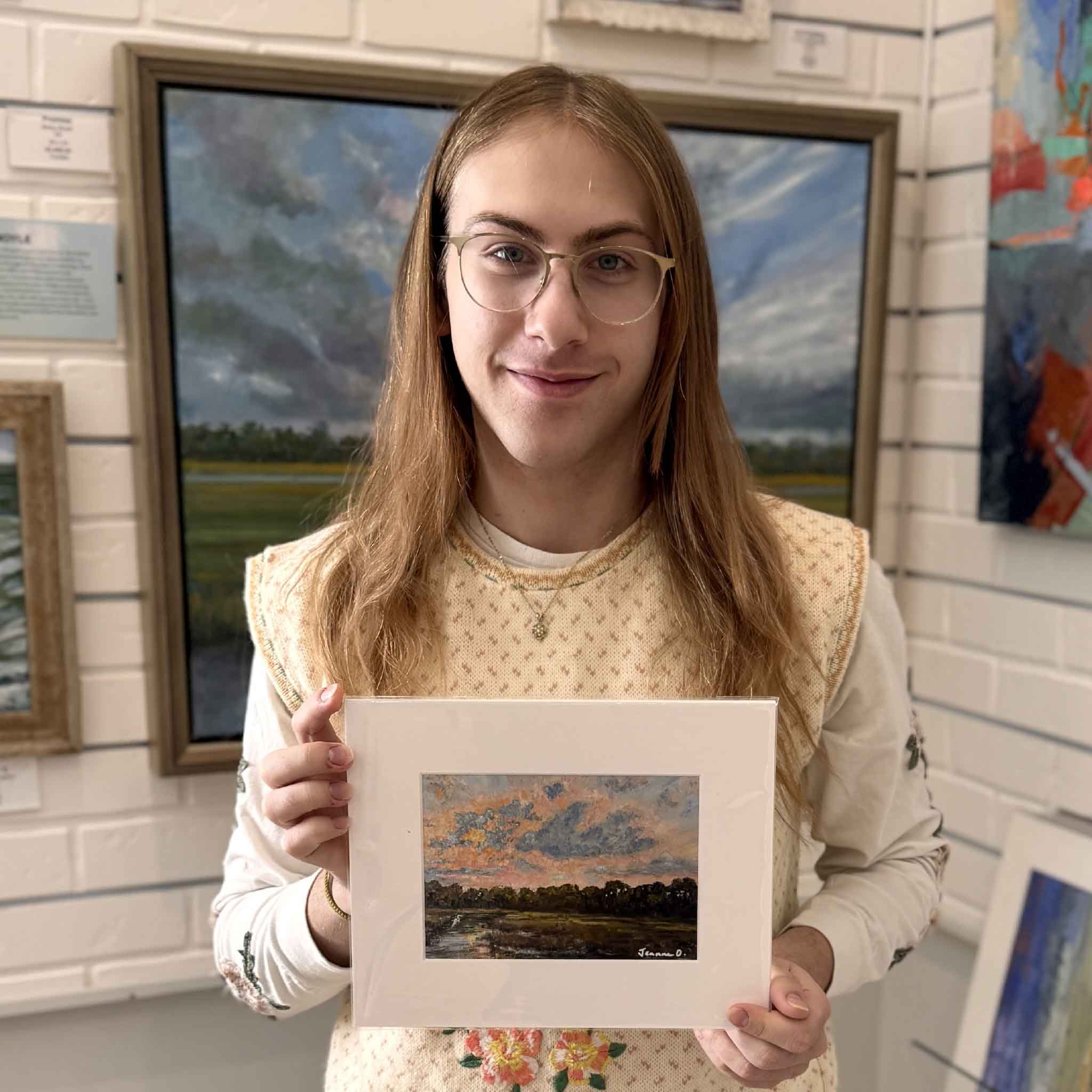 Gray Man Gallery team member holding Jeanne O’Neal’s Pawleys Marsh 8x10 matted giclée to show scale in the gallery.
