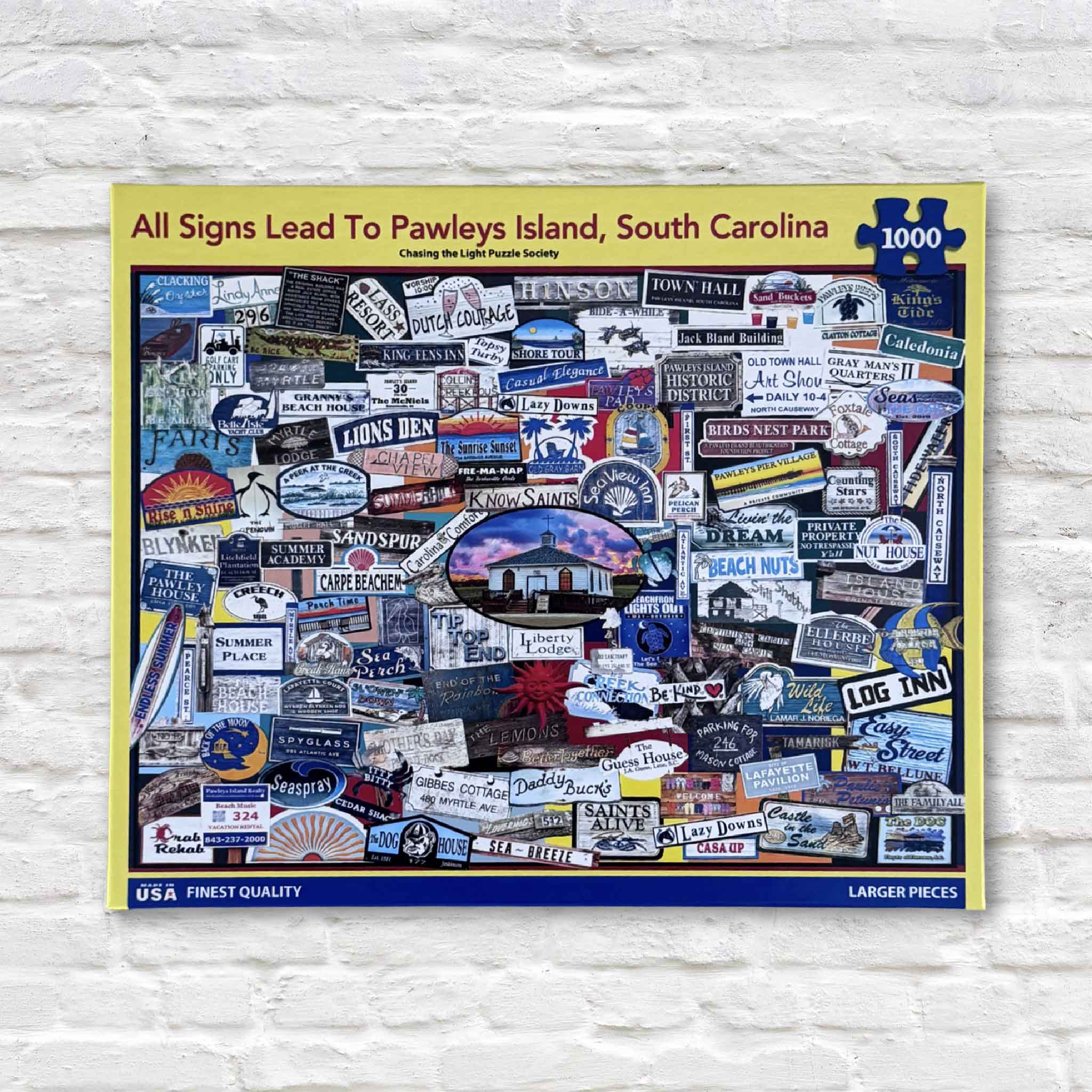 Front of the All Signs Lead to Pawleys Island 1,000-piece puzzle by Tanya Ackerman, featuring colorful iconic beach house signs from Pawleys Island, South Carolina.
