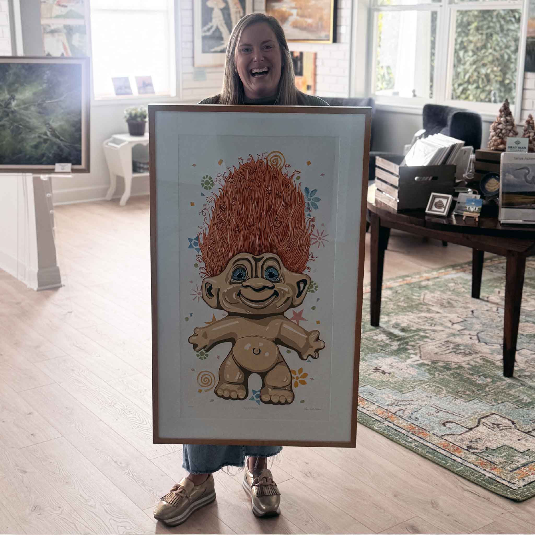 Gallery team member holding Hair Up by local artist Laurie McIntosh to show scale, a large original linocut relief print photographed inside Gray Man Gallery.