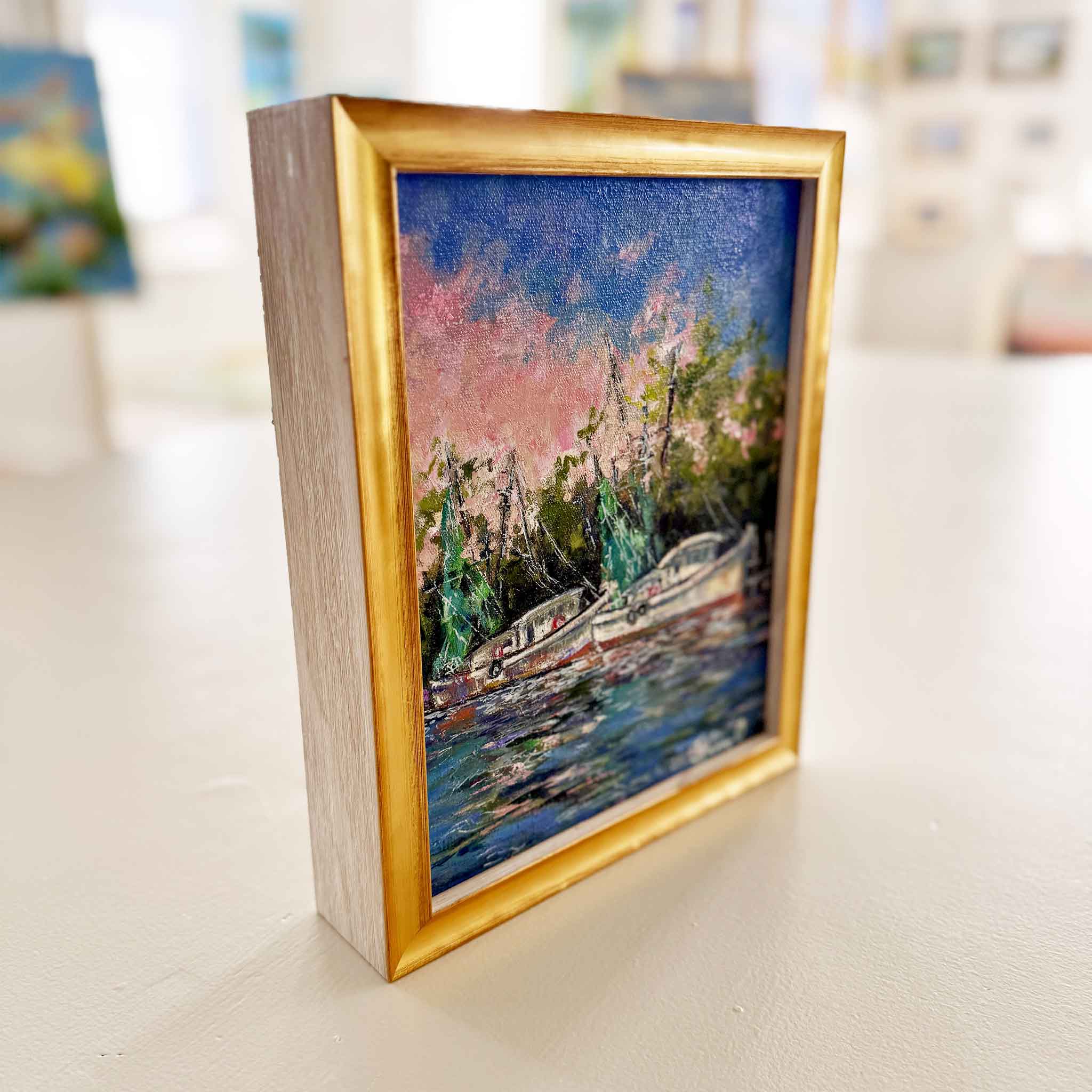 Angled side view of “Evening Light” original oil painting by Jeanne O’Neal showing gold frame profile, expressive brushwork, and layered sunset harbor scene, highlighting professional custom framing and coastal art presentation at Gray Man Gallery in Pawleys Island South Carolina