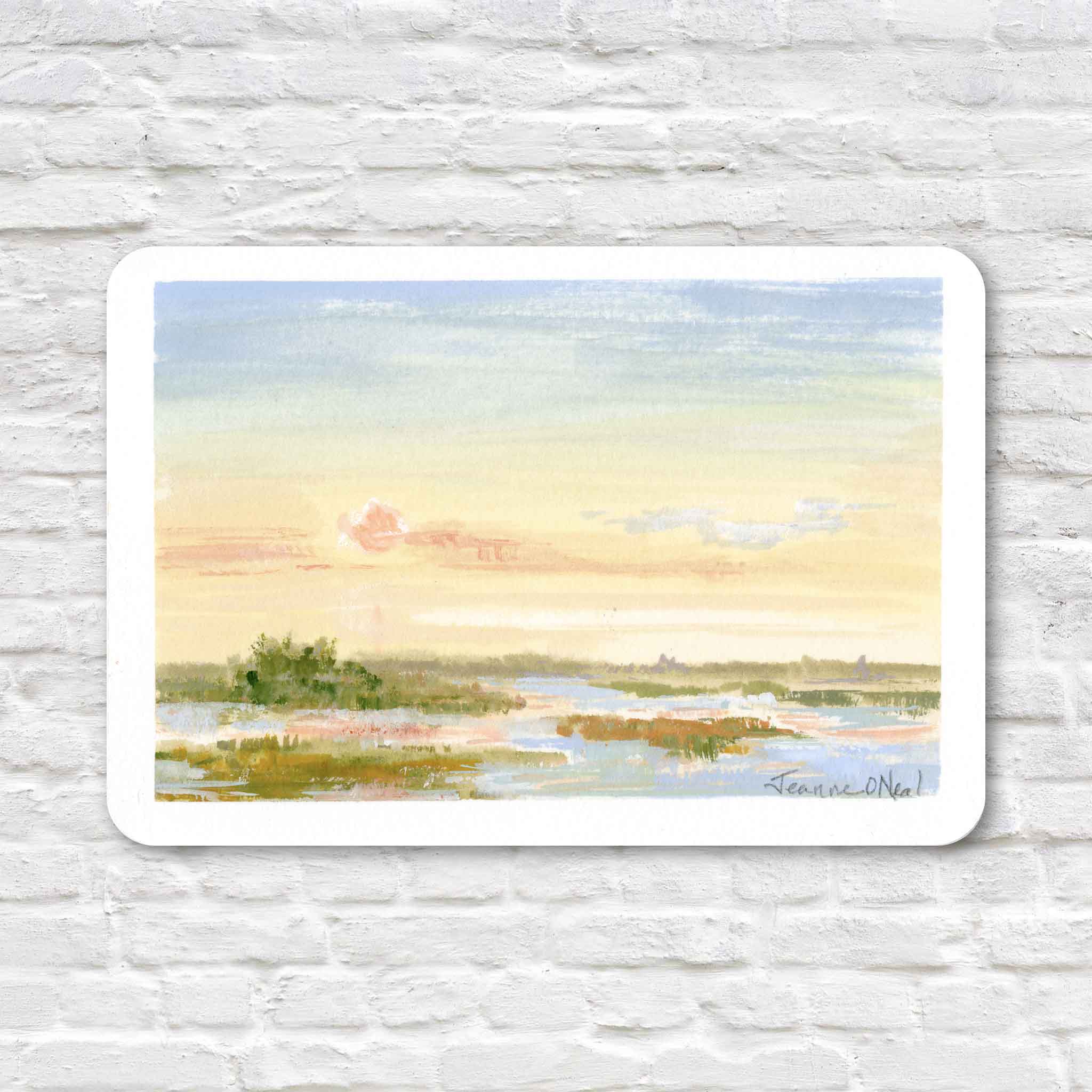 First Light by Jeanne O’Neal original gouache coastal landscape painted on postcard featuring soft pastel sky in pale yellow and blue with calm water and low island forms at Gray Man Gallery Pawleys Island