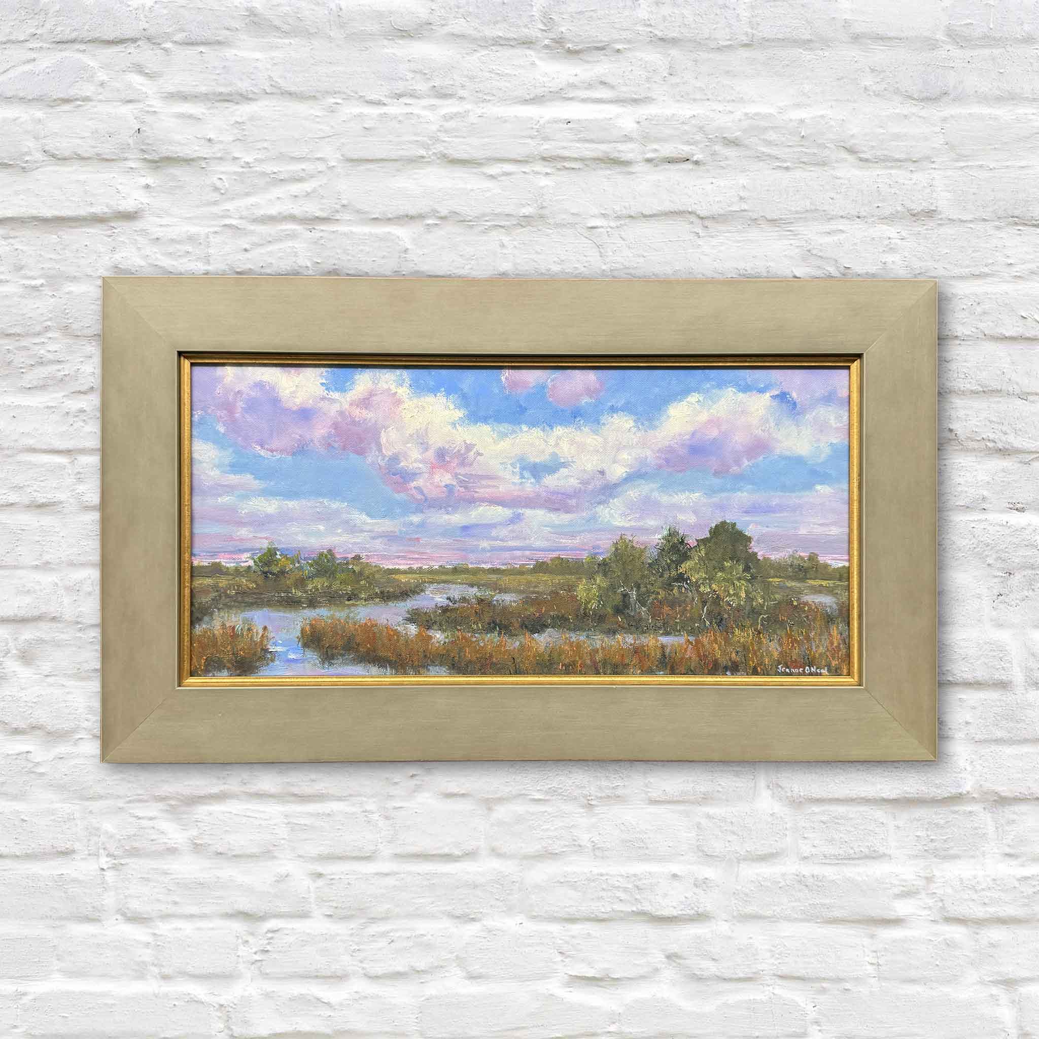 Marsh Reverie by local artist Jeanne O’Neal is an original framed oil painting featuring a luminous Lowcountry marsh landscape beneath lavender and pink clouds. Painted in expressive layered brushwork with winding tidal creeks, marsh grasses, and soft coastal light, this original artwork is available at Gray Man Gallery in Pawleys Island, South Carolina.