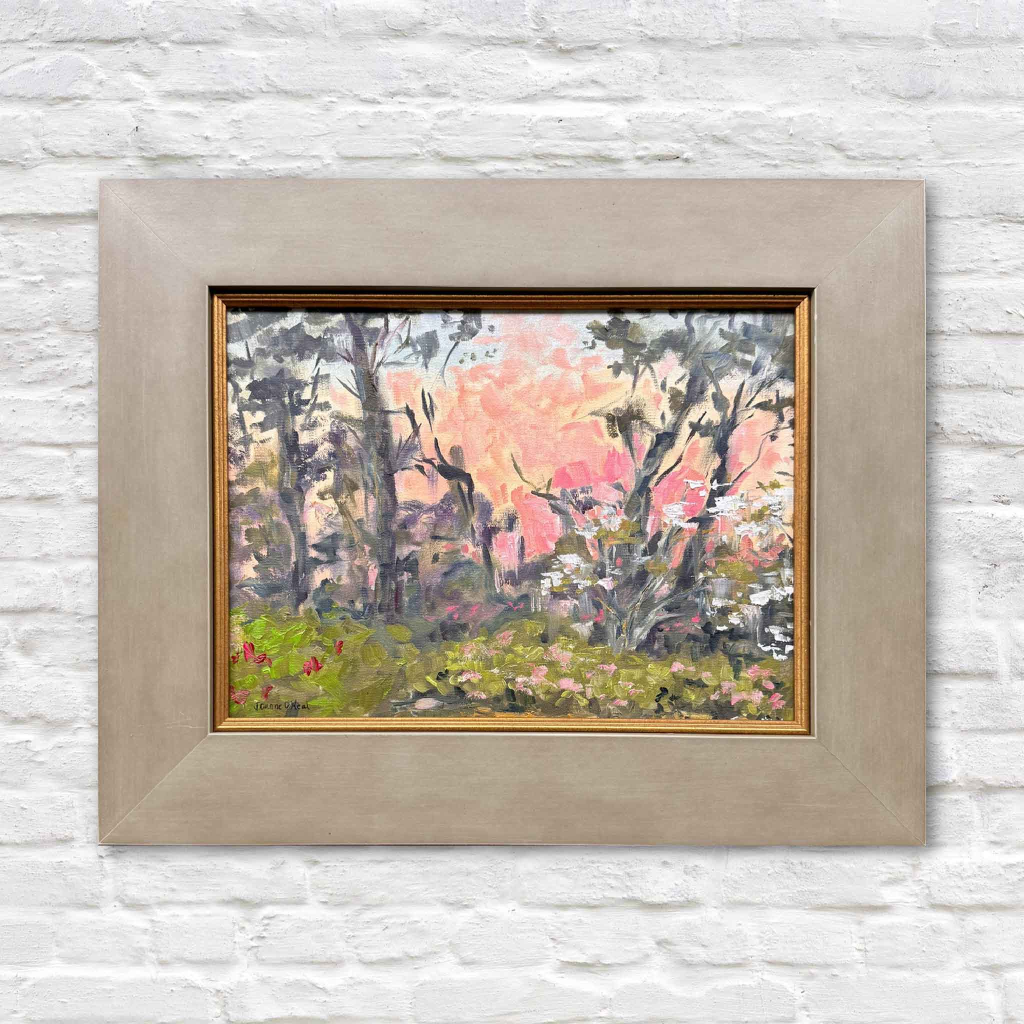 Pink Canopy by Jeanne O’Neal original oil painting created at Brookgreen Gardens featuring Lowcountry trees, blooming spring florals, and a glowing pink and coral sky in custom frame at Gray Man Gallery Pawleys Island