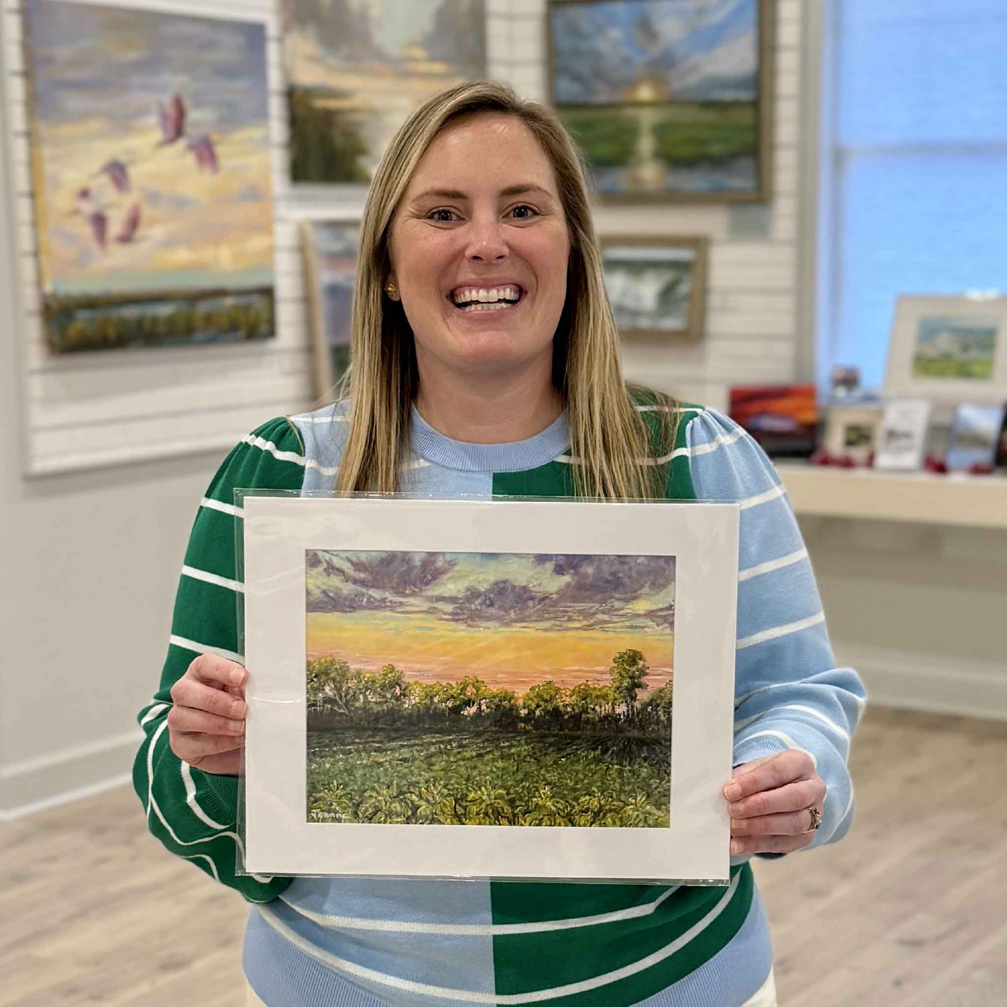 Local artist Jeanne O’Neal Tobacco Fields landscape art print held by Bordy inside Gray Man Gallery in Pawleys Island South Carolina, 11x14 matted fine art giclée featuring Lowcountry fields, sunset sky, coastal colors, and Southern farmland heritage, available at Gray Man Gallery custom framing and local art shop