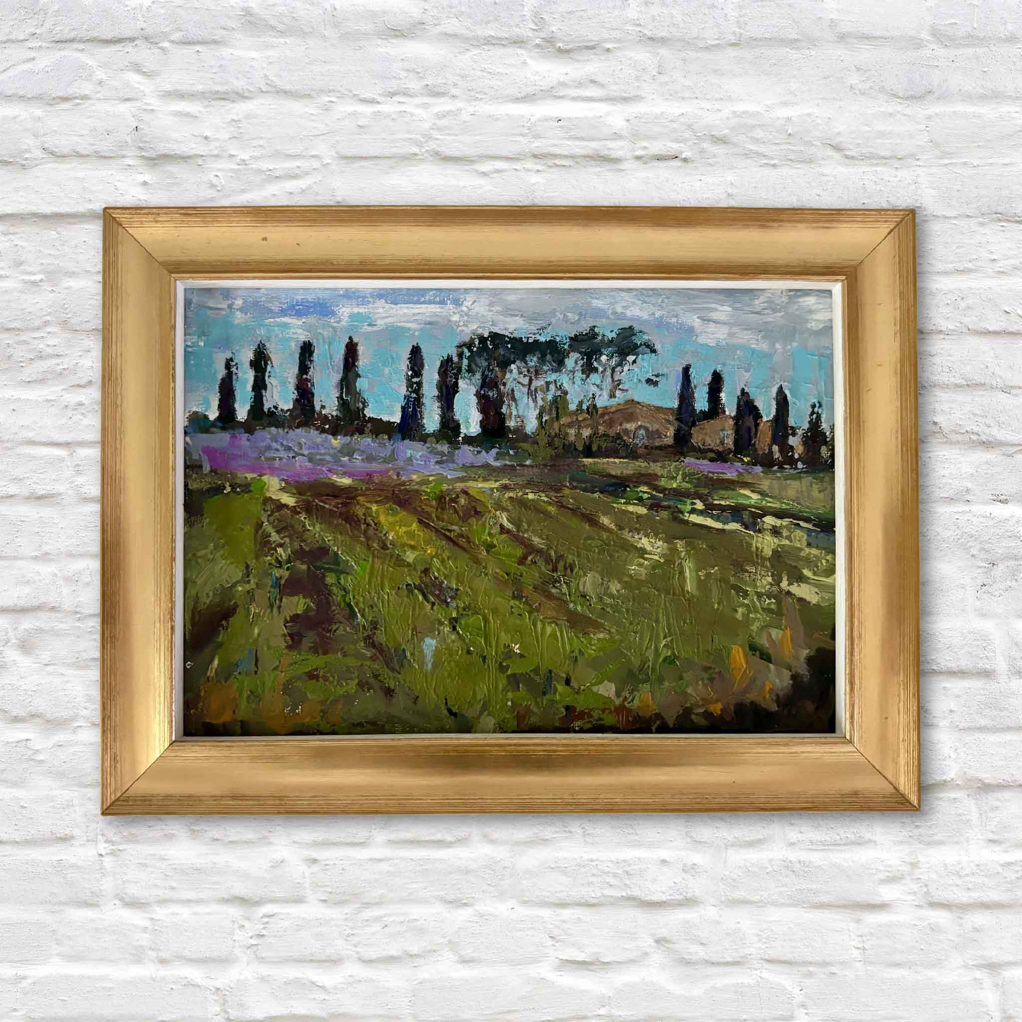 Tuscan Summer by Jeanne O'Neal, an original oil painting featuring sunlit green fields, lavender blooms, cypress trees, and an Italian farmhouse, presented in the artist's signature gold frame at Gray Man Gallery.