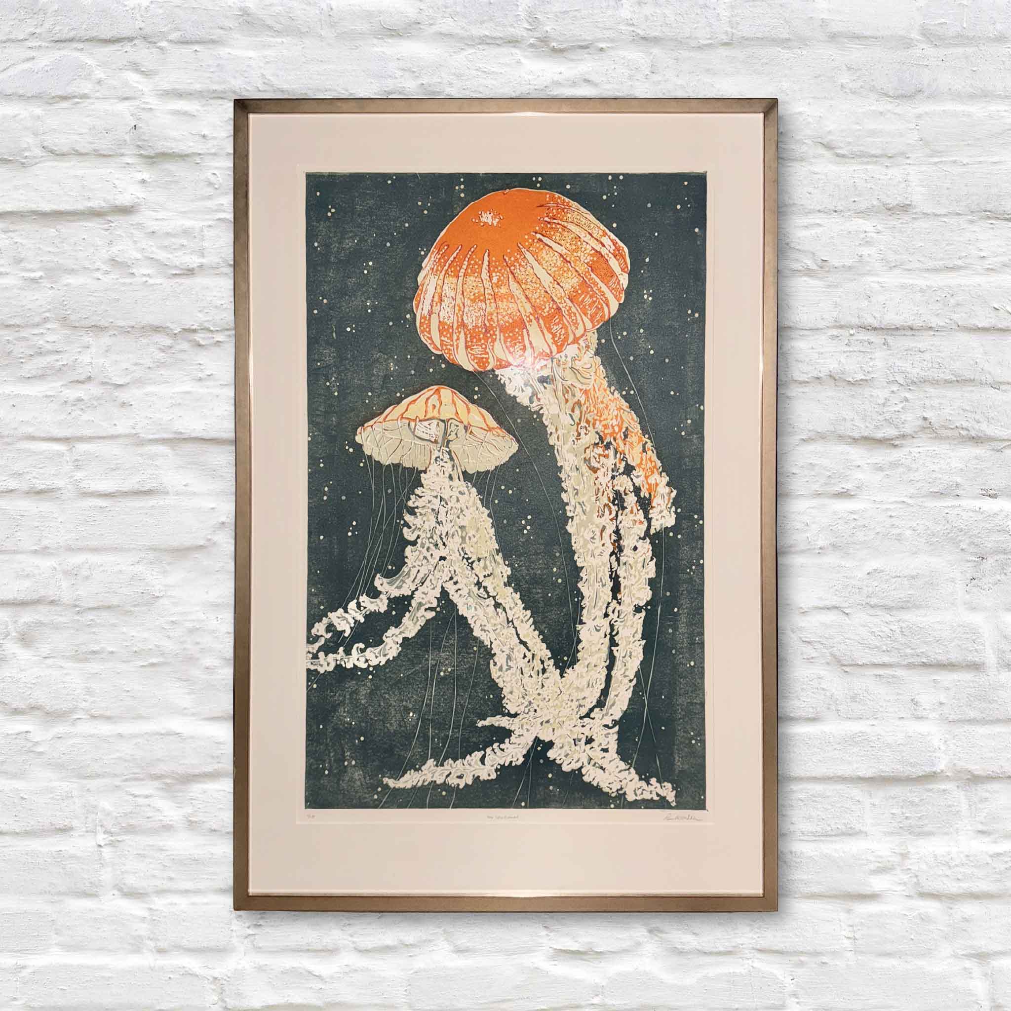 Jelly Dance by local South Carolina artist Laurie McIntosh, a Blue Ribbon-winning reduction linocut print featuring luminous jellyfish in coral and ivory tones floating through deep coastal waters, professionally framed at Gray Man Gallery in Pawleys Island.