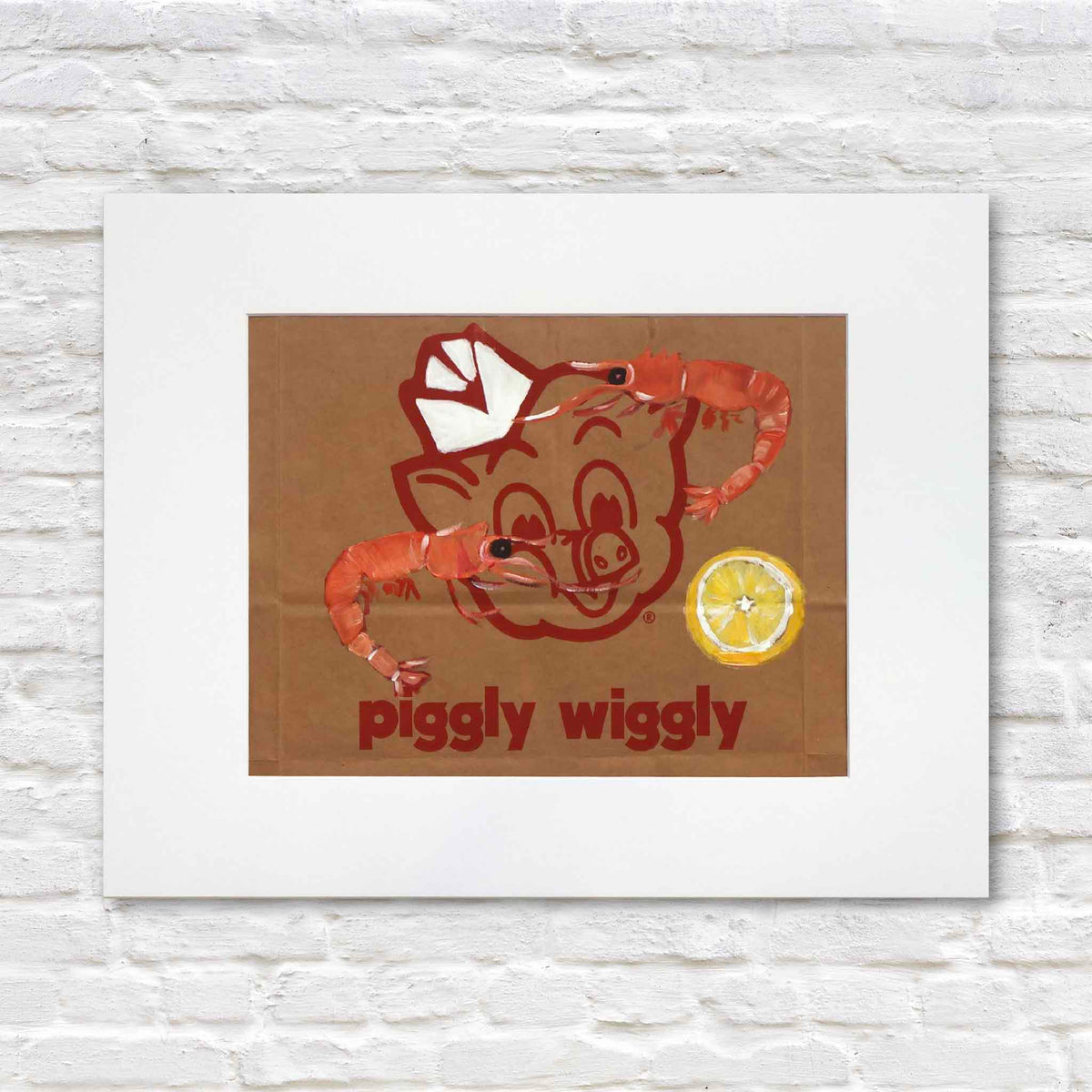 Peel & Eat, an original acrylic painting by local artist Jenny Reynolds featuring two pink-orange shrimp and a yellow lemon slice surrounding the red Piggly Wiggly pig logo on a genuine brown paper grocery bag. Displayed in a wide white mat at Gray Man Gallery in Pawleys Island, South Carolina.