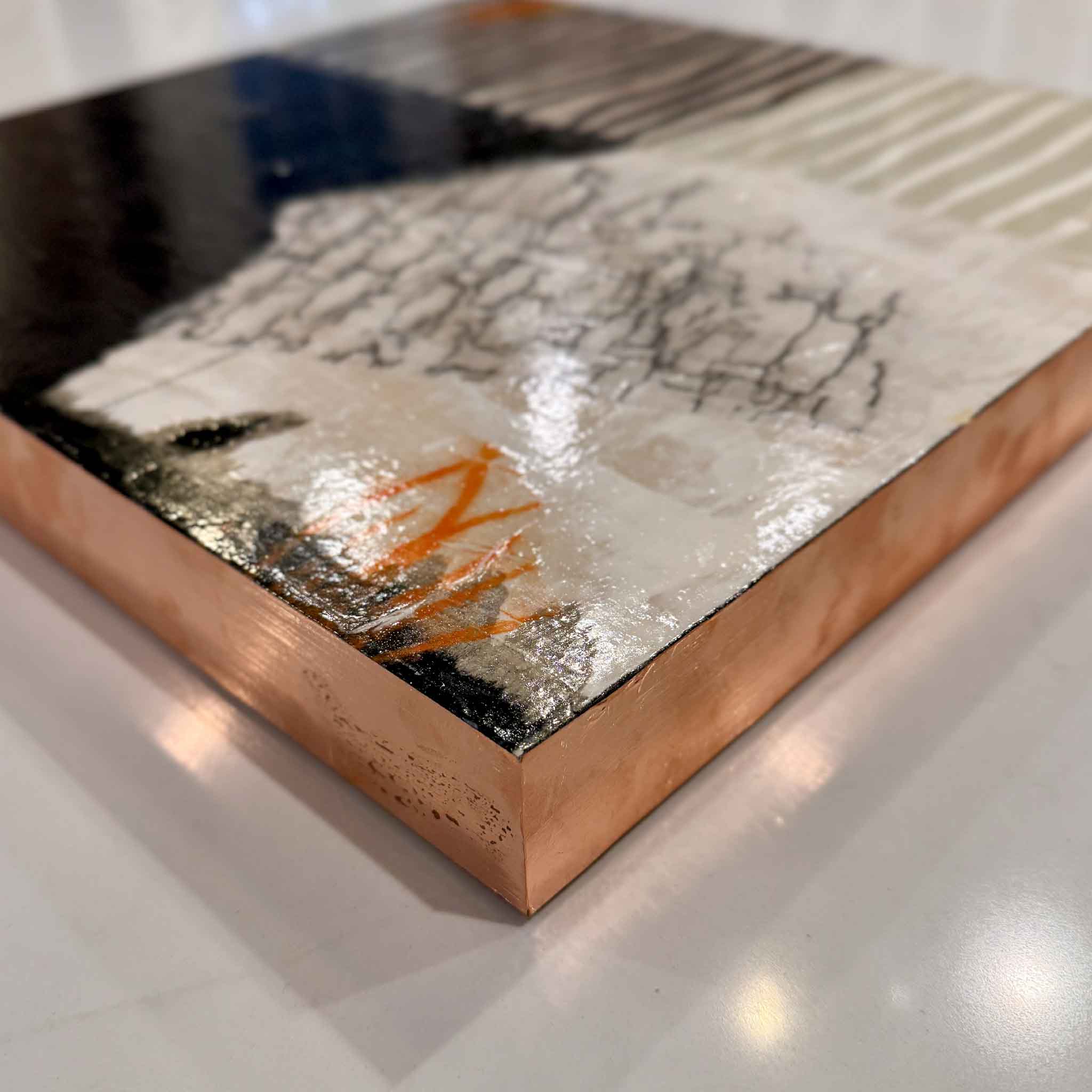 Side detail of ‘A Touch of Orange’ by Laurie McIntosh, showing the glossy surface and rose-gold leaf edges of the mixed-media artwork.