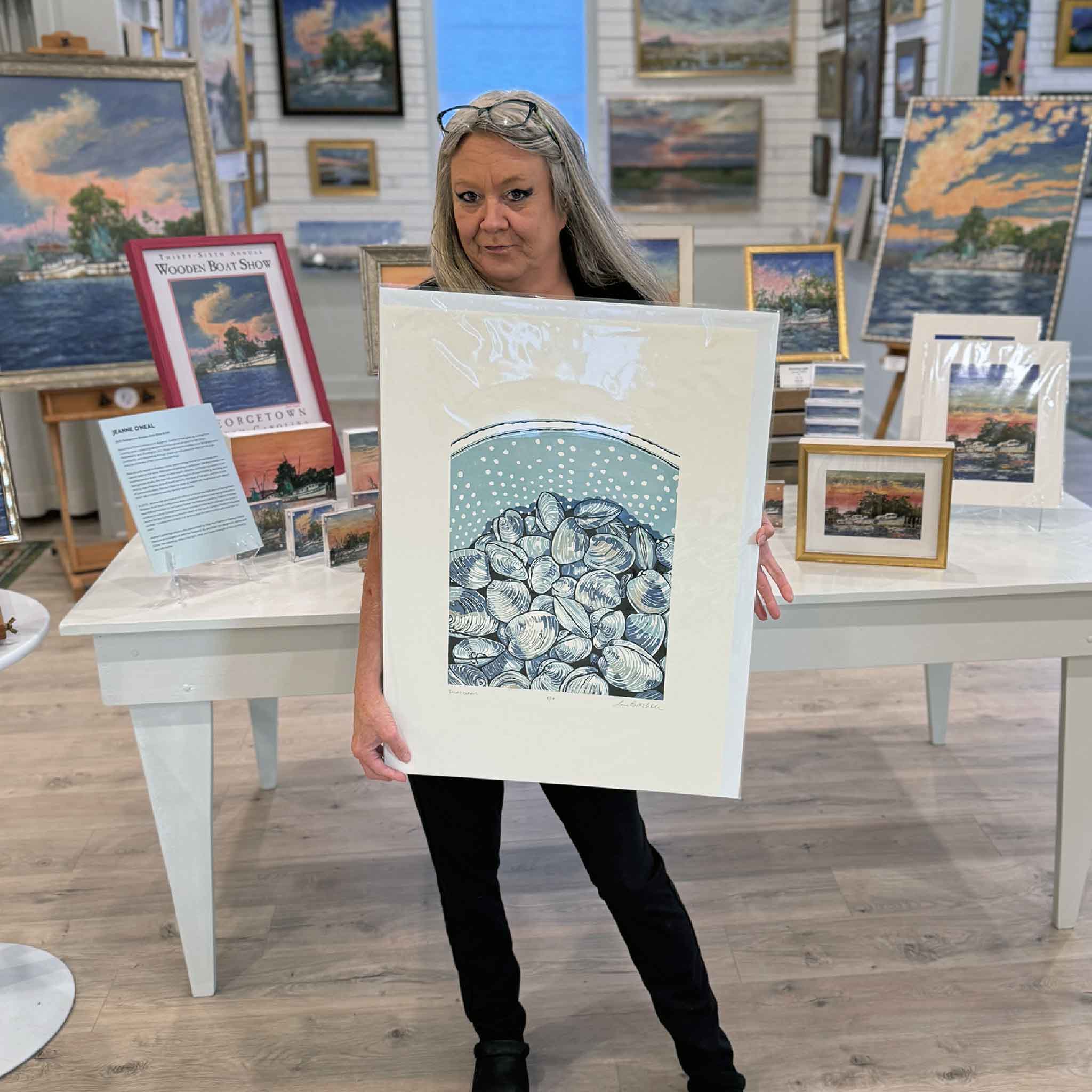 “Inlet Clams” original linocut by Laurie McIntosh held at Gray Man Gallery, featuring a coastal pile of hand-carved clams in cool blue tones.