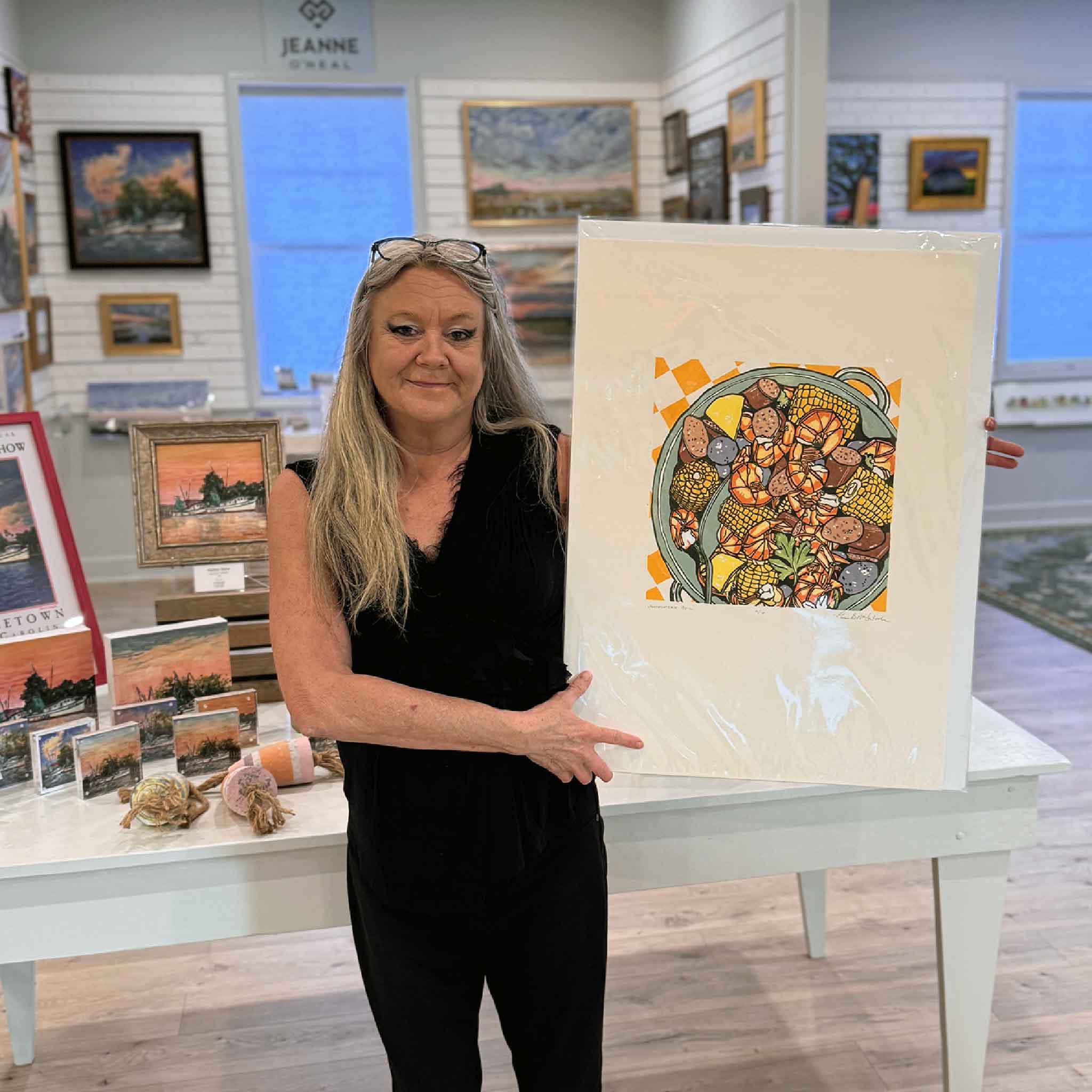 “Lowcountry Boil” original linocut by Laurie McIntosh held at Gray Man Gallery, featuring shrimp, corn, potatoes, and sausage in bold coastal colors.