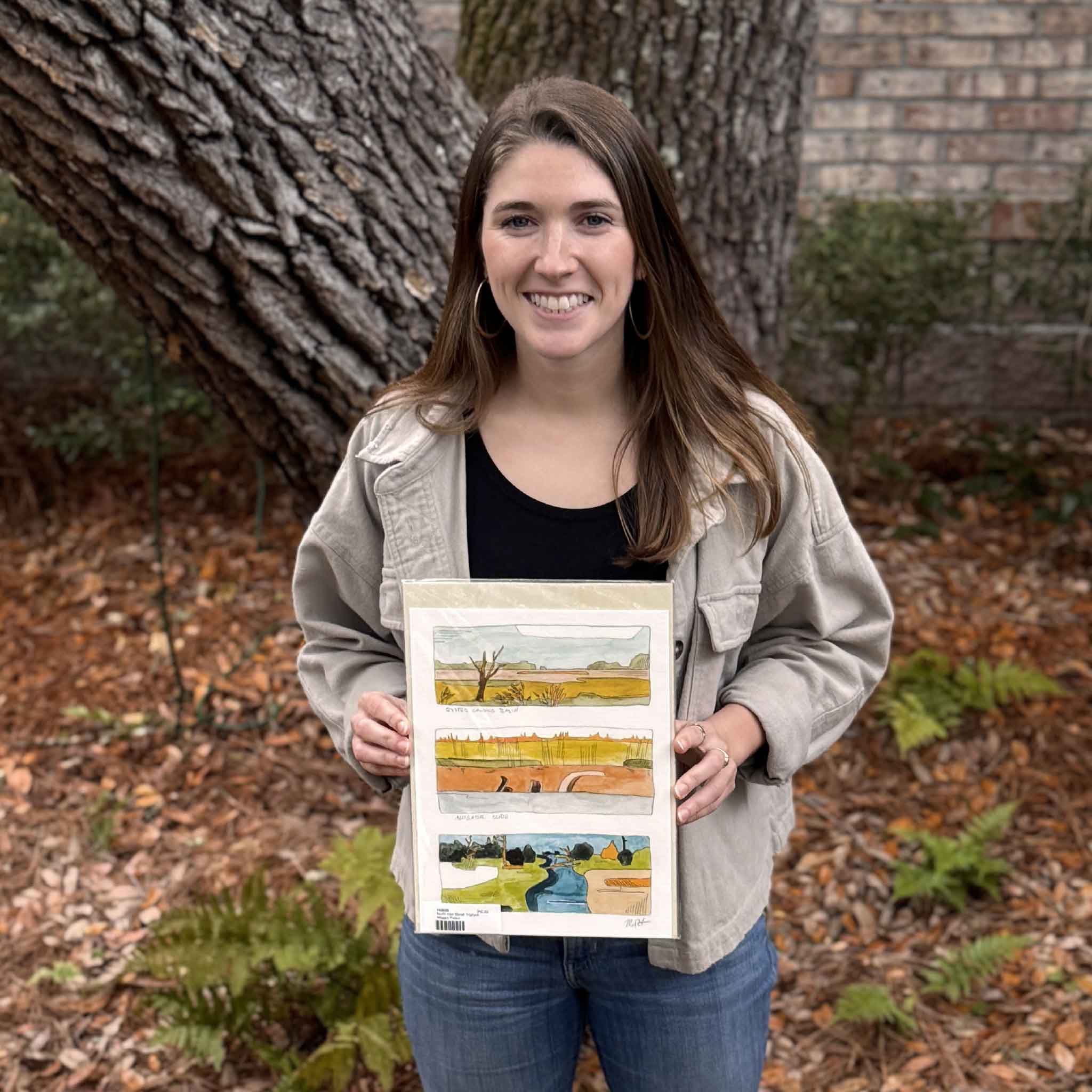 Maggie Pelton, local artist, holding her North Inlet Marsh Triptych fine art print outdoors, featuring three abstract marsh scenes inspired by the Lowcountry waterways of Georgetown and Pawleys Island, available at Gray Man Gallery in Pawleys Island, South Carolina