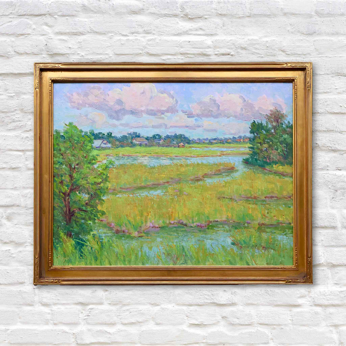 Early Fall Marsh original oil painting by local artist Michael Rogan featuring winding tidal creeks, green and gold marsh grass, distant homes and soft clouds, framed in gold at Gray Man Gallery in Pawleys Island, South Carolina.