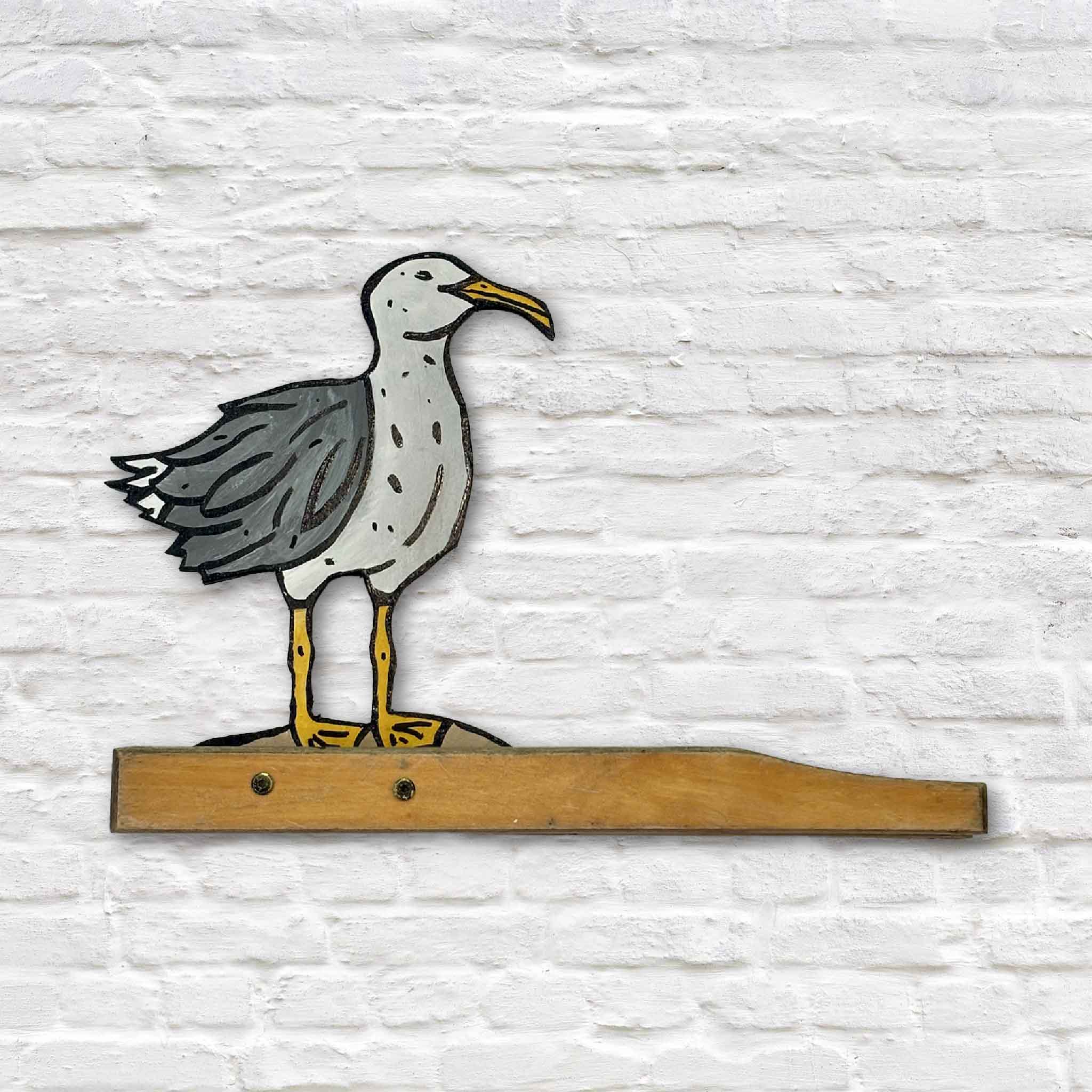 Seagull #9 by Nick Kawczynski displayed at Gray Man Gallery in Pawleys Island, South Carolina. This one-of-a-kind coastal sculpture is handcrafted from reclaimed marine-grade plywood salvaged through the artist's volunteer work with the Lowcountry Maritime Society and mounted to a weathered reclaimed wooden base.