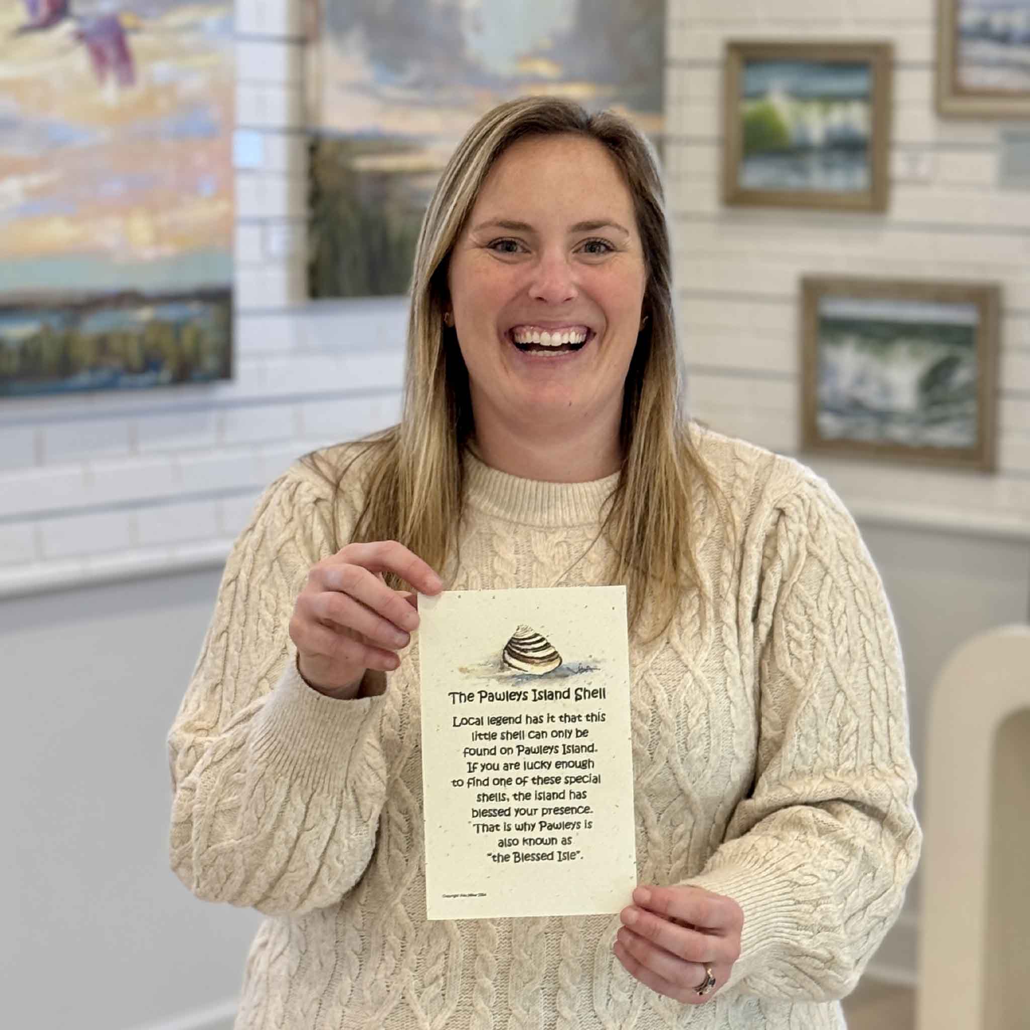 Bordy holding Pawleys Island Shell Legend print by local artist Vida Miller featuring the iconic ridged Pawleys Island shell and Blessed Isle legend at Gray Man Gallery