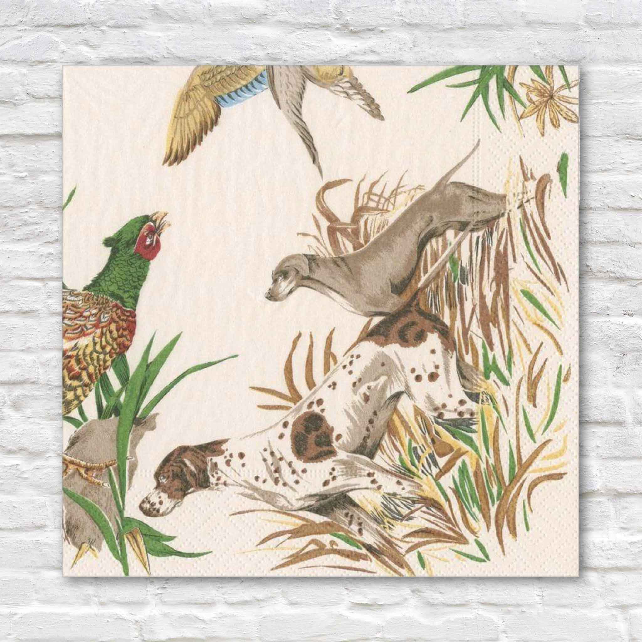 Pierre Frey Sologne luncheon napkins by Caspari featuring elegant sporting artwork with English pointer hunting dogs, a colorful pheasant, and birds in flight through tall grasses. These premium triple-ply luncheon napkins blend classic French country style with exceptional Caspari quality and are available at Gray Man Gallery in Pawleys Island, South Carolina for entertaining, hunting lodges, sporting homes, and refined everyday dining.
