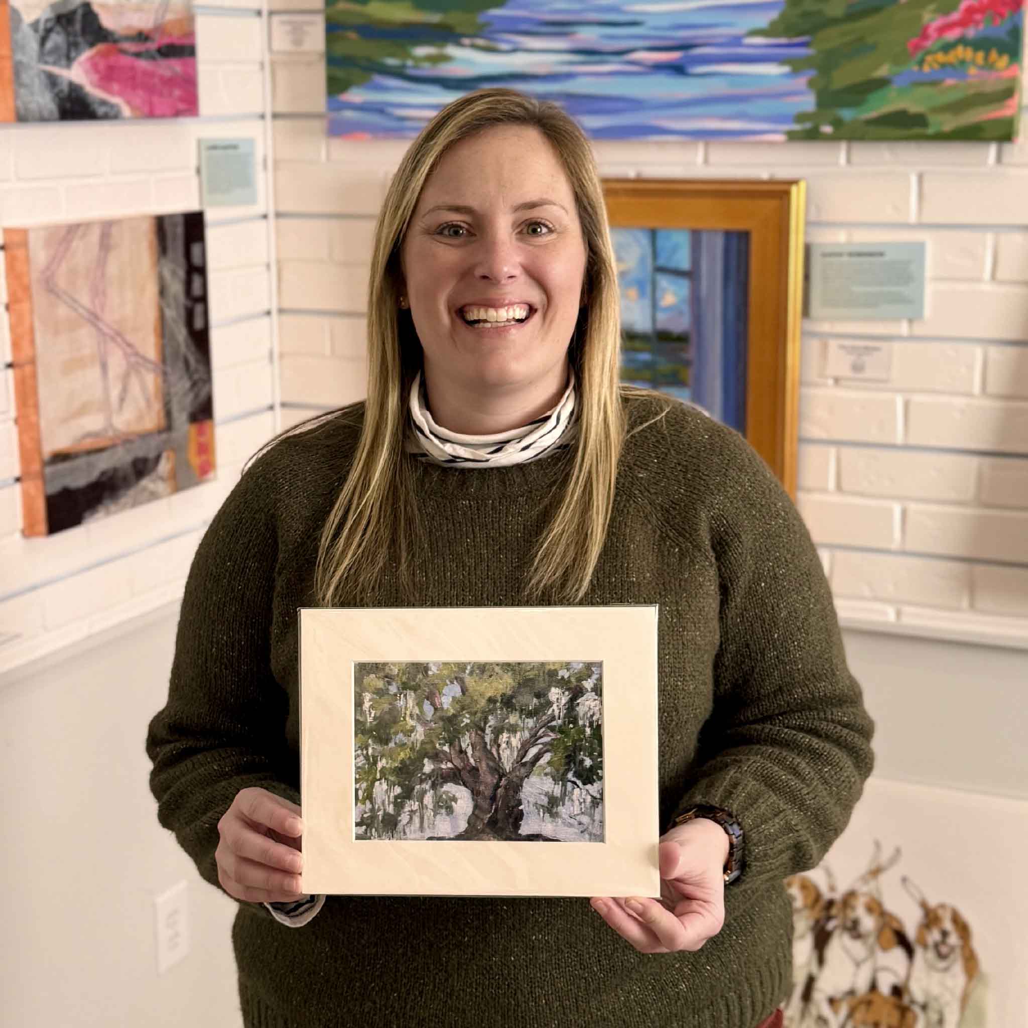 Gray Man Gallery staff member Bordy holding Quiet Strength fine art giclée print by Jeanne O’Neal, showing scale and presentation of professionally matted coastal artwork in Pawleys Island SC gallery exclusive to Gray Man Gallery