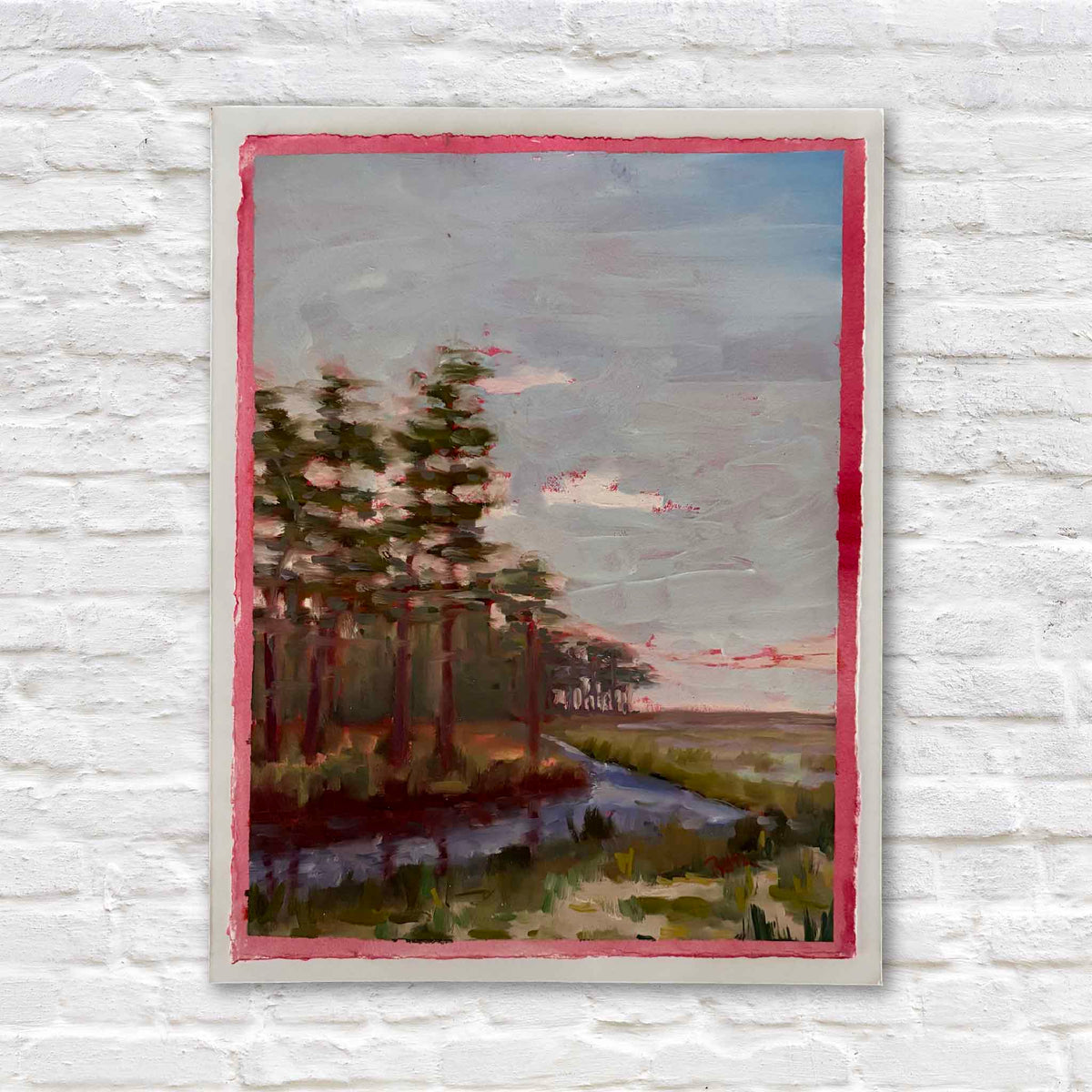 South Island Pines #217 original oil on paper by local artist Retta Dotterer featuring tall pines, a winding waterway and South Carolina marsh beneath a soft blue-gray sky, with a hand-painted pink border at Gray Man Gallery in Pawleys Island.