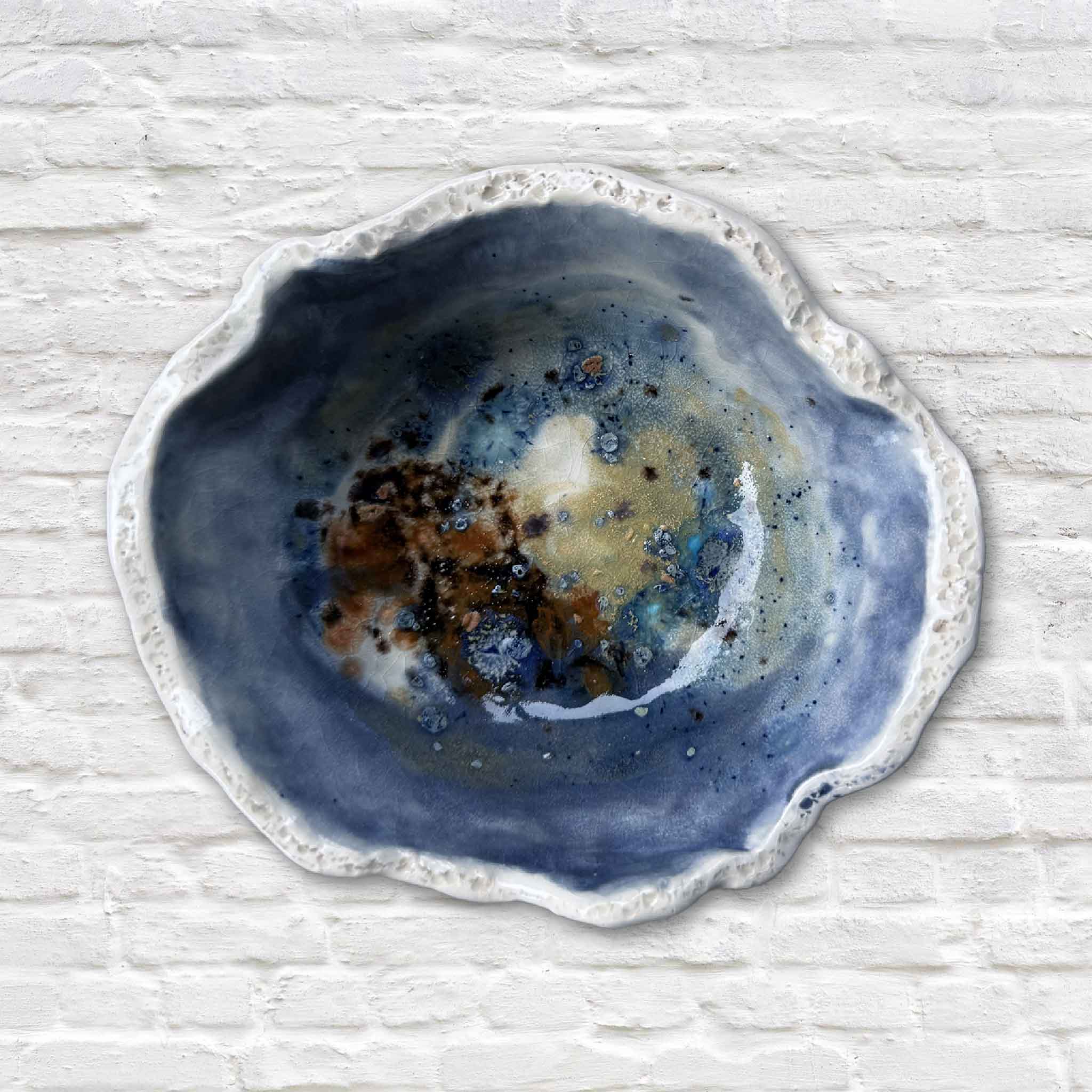 Vida Miller Seaspray bowl featuring deep ocean-blue glazing, sandy rim, and natural sculpted form.