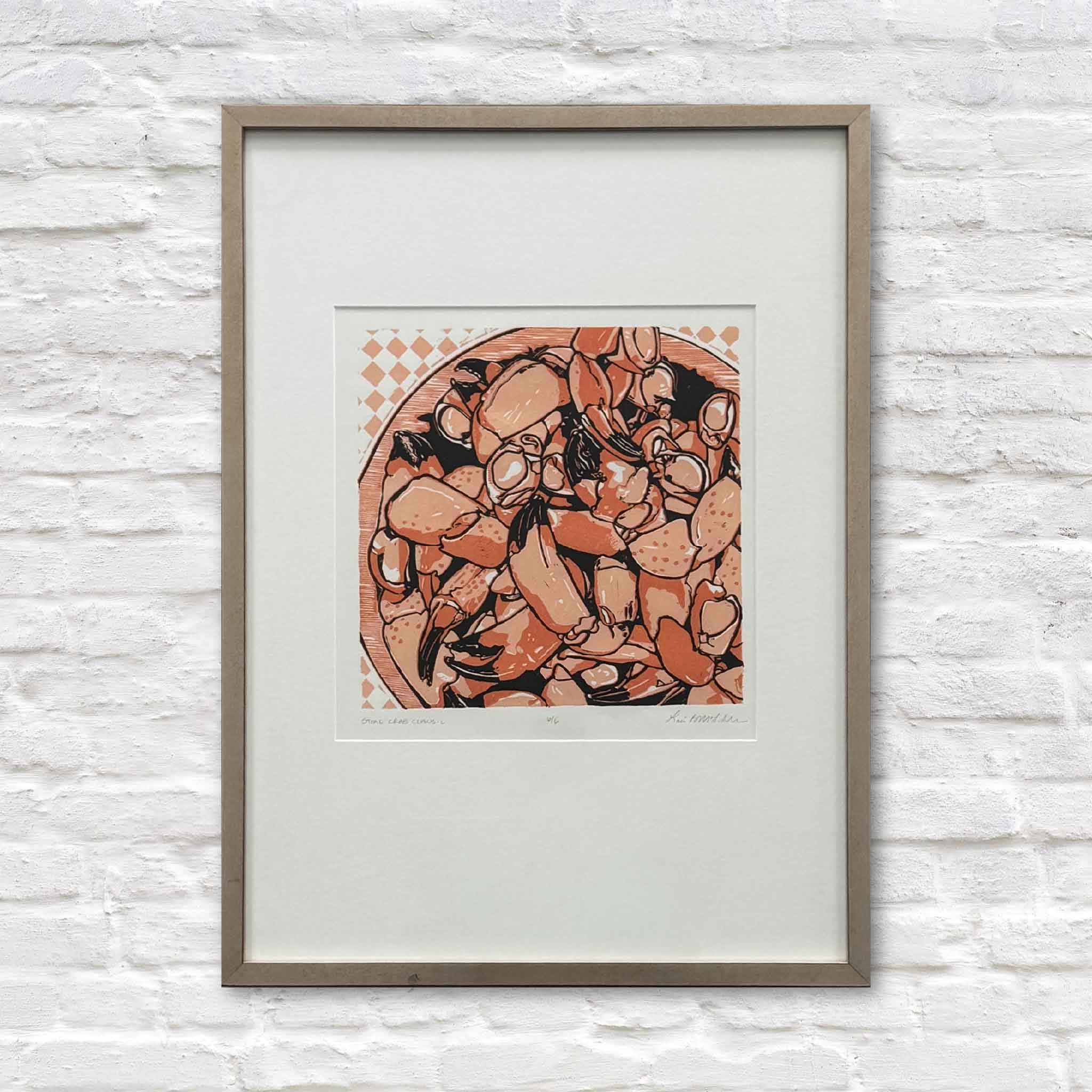 Framed original stone crab claws linocut reduction by local artist Laurie McIntosh, photographed at Gray Man Gallery in Pawleys Island, South Carolina.