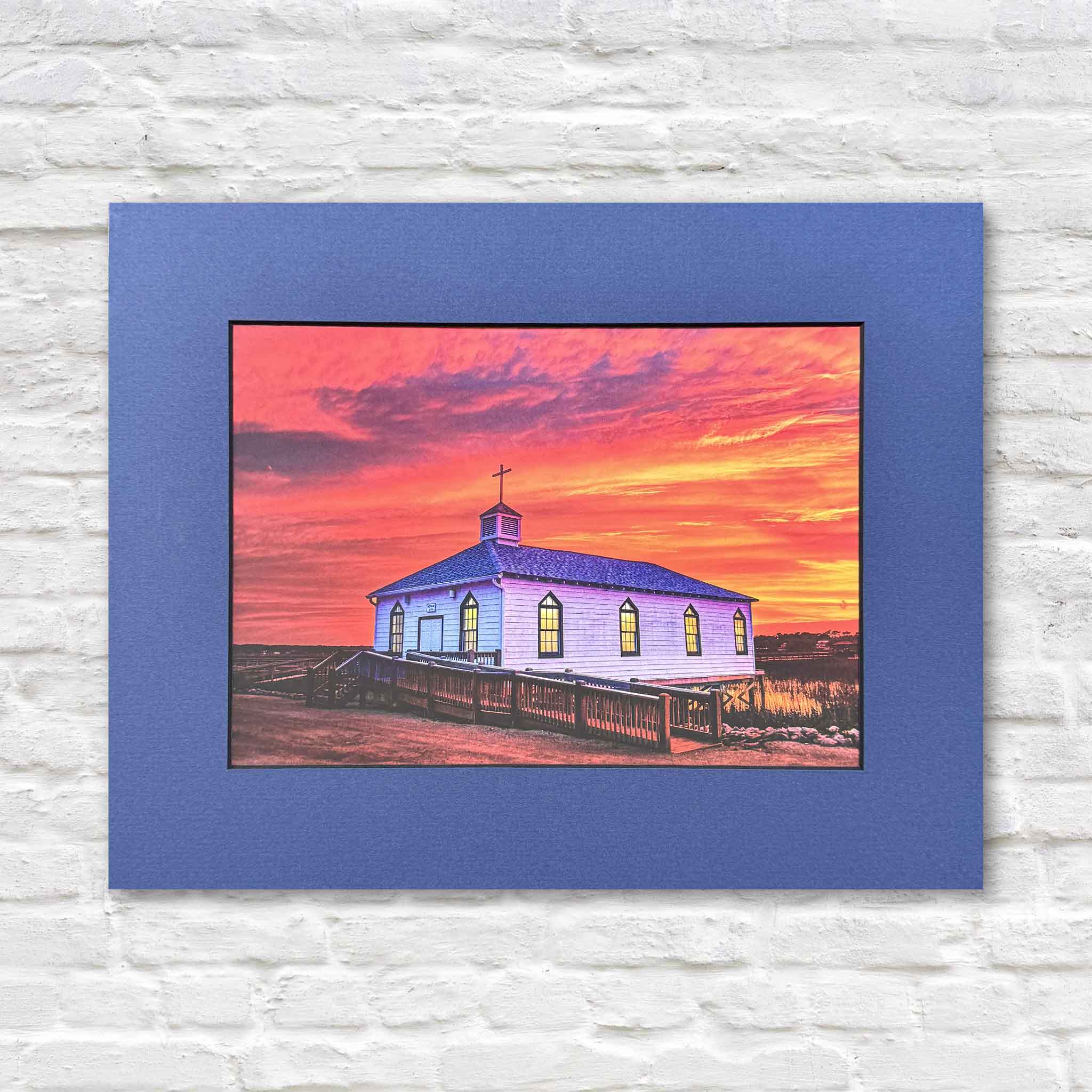 Matted coastal photography print by local Pawleys Island photographer Tanya Ackerman featuring the historic Pawleys Island chapel beneath a vivid pink, orange, and purple sunset sky. This collectible print was created from the cover of her book Pawleys Island: Seasons of Light and is available at Gray Man Gallery.