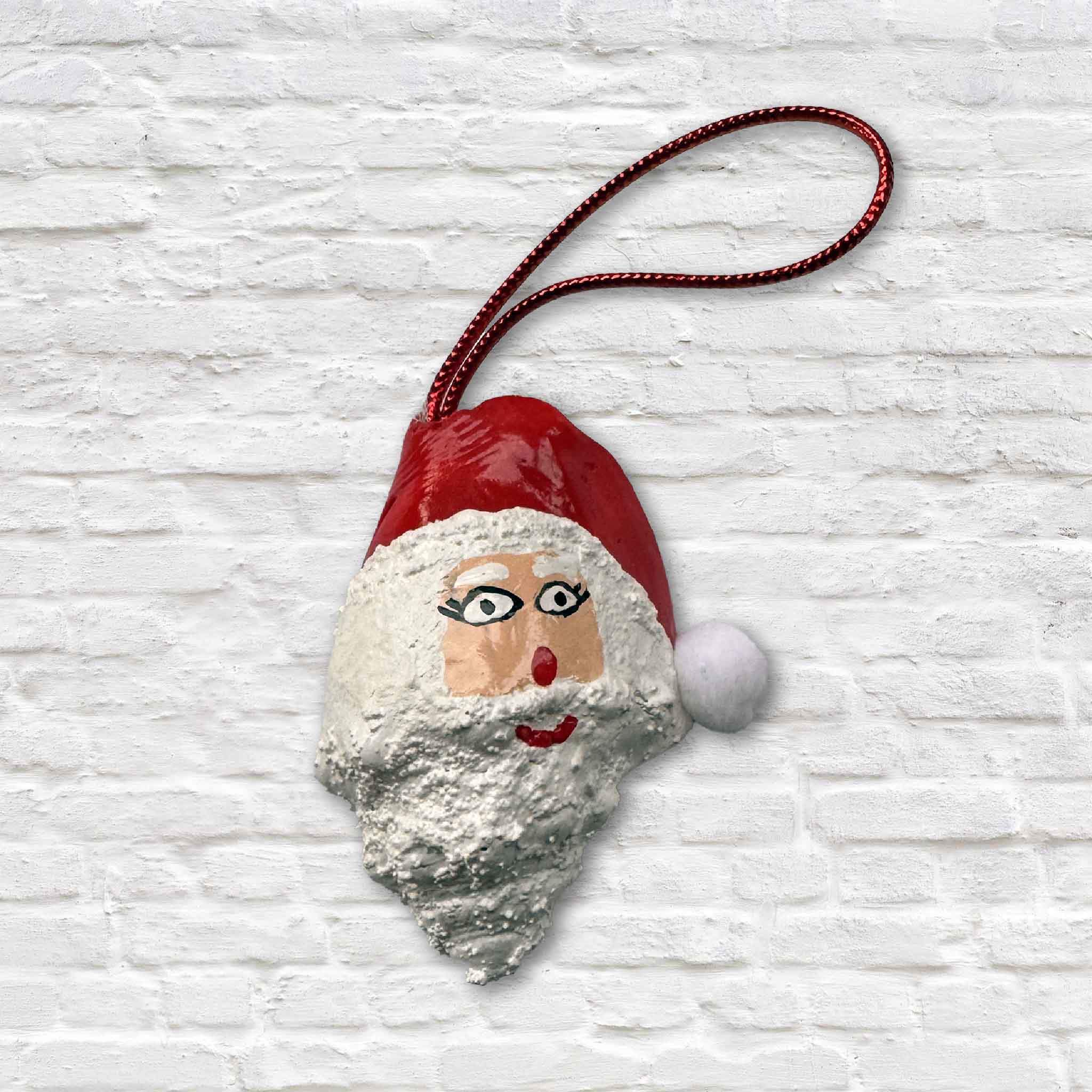 Hand-painted conch shell Santa ornament by Tootsie Watkins with red hat and textured white beard.