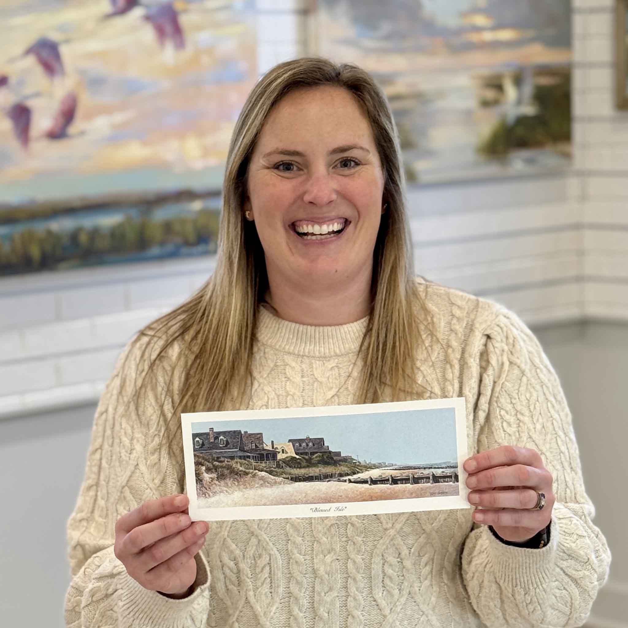 Bordy holding Blessed Isle panoramic coastal art print by local artist Tripp Harrison depicting Pawleys Island South End oceanfront cottages, dunes, and shoreline available at Gray Man Gallery in Pawleys Island South Carolina