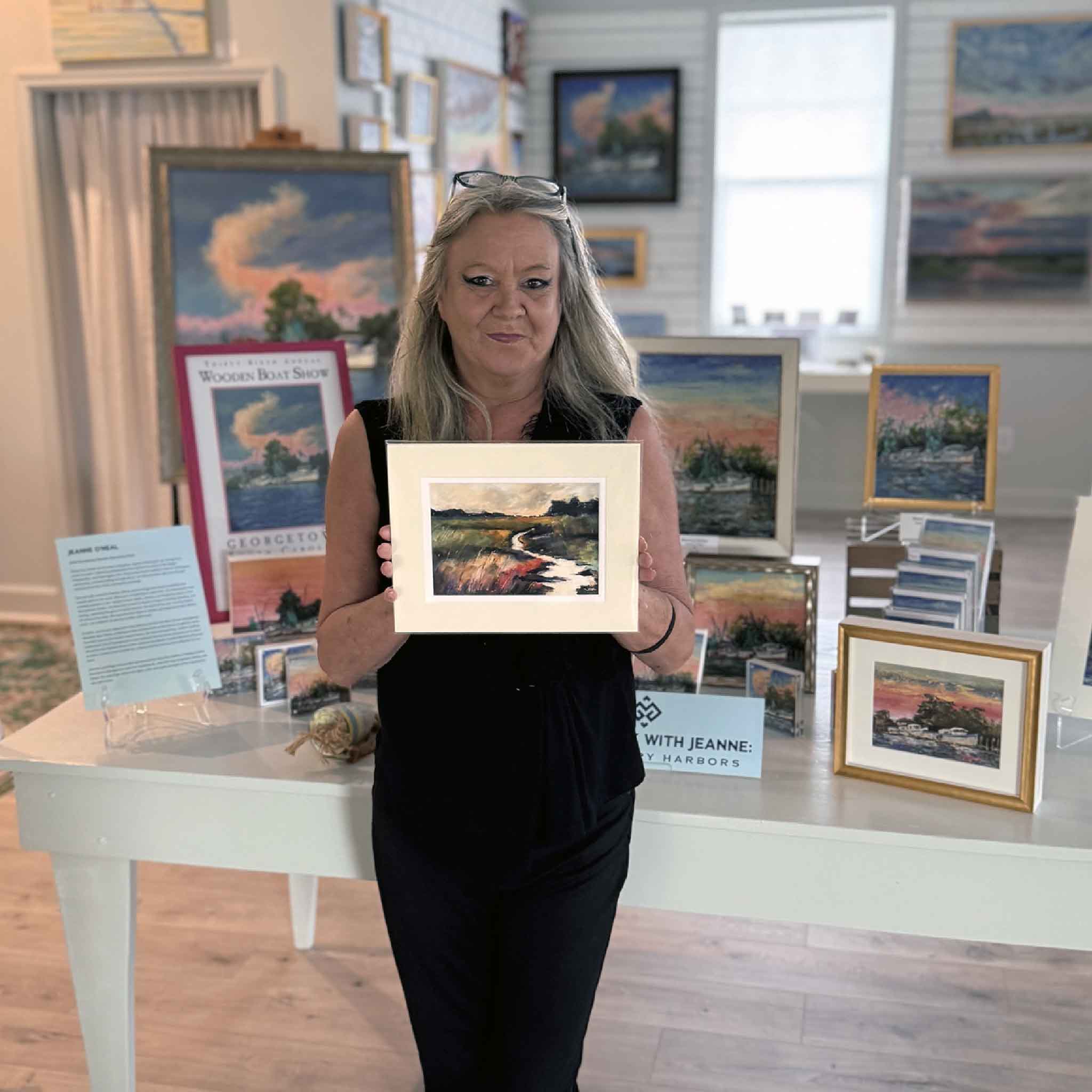 Charlotte holding Marsh #3 matted pastel print inside Gray Man Gallery for scale