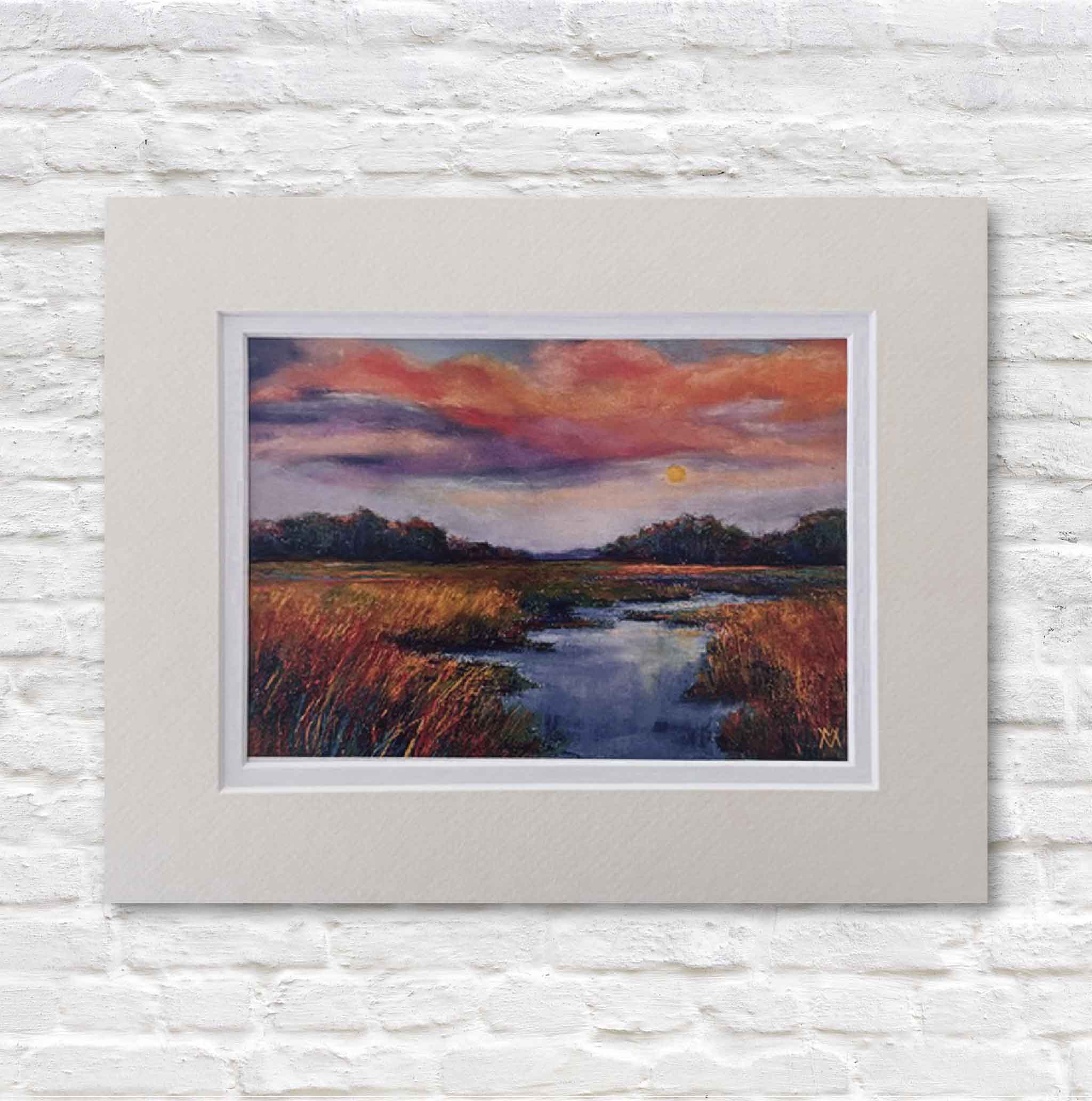 matted painting of a sunset over the marsh on a white brick wall.