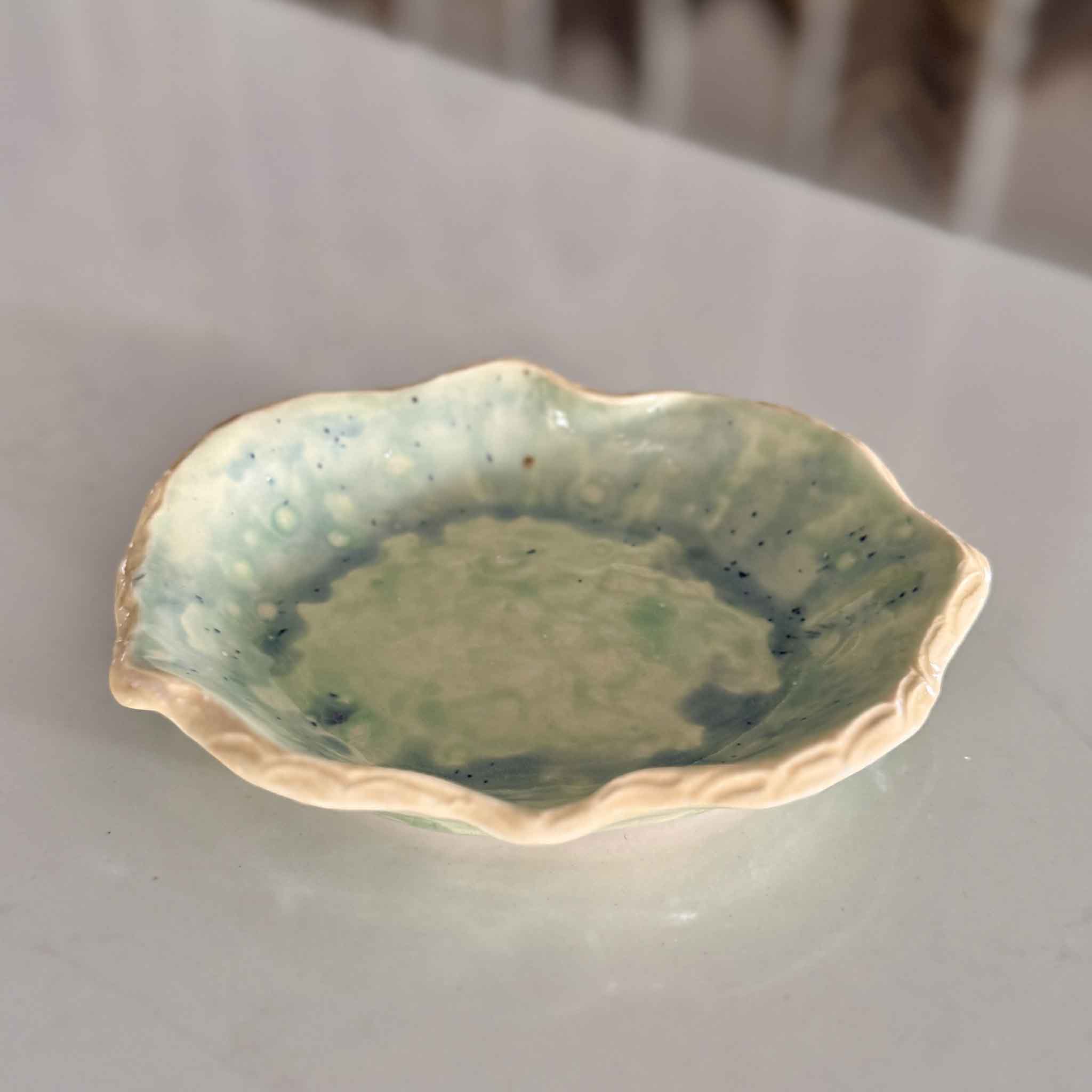 Angled view of Marsh Drift Bowl by Vida Miller showing organic scalloped form and painterly seafoam glaze, handcrafted ceramic available at Gray Man Gallery Pawleys Island