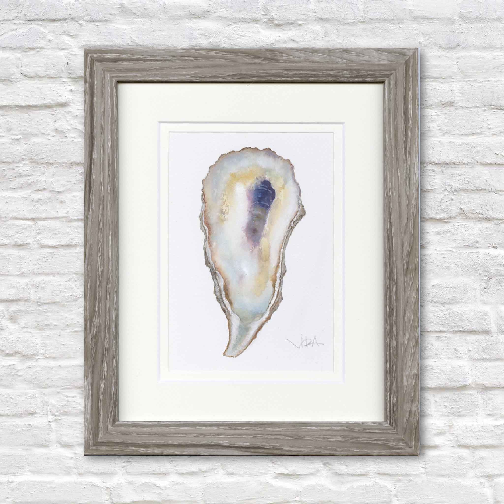 Original watercolor painting, Pawleys Oyster Shell IX by Pawleys Island artist Vida Miller, professionally double matted and framed in a weathered gray wood frame. Rich pearl whites, warm honey tones, soft blue washes, and a dramatic indigo center highlight the unique form of this original oyster shell, creating elegant coastal wall art inspired by Pawleys Island.