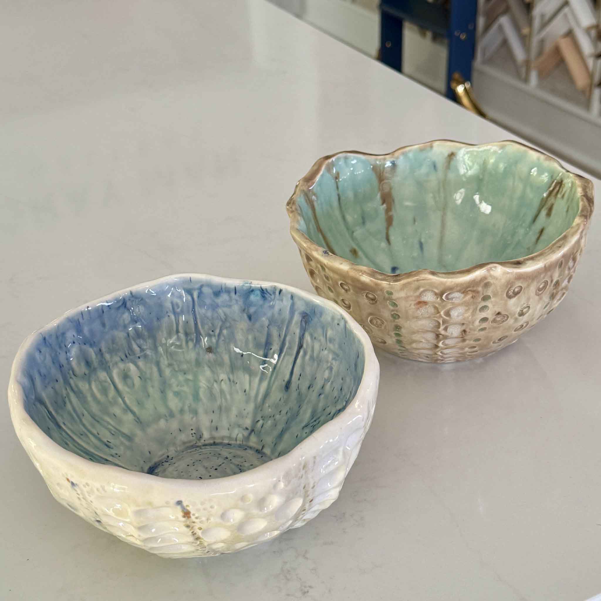 Two handmade Tidepool Texture Bowls by Pawleys Island artist Vida Miller featuring sculptural coastal textures, layered seafoam and sand glazes, and handbuilt ceramic forms inspired by shells, barnacles, and Lowcountry tidepools at Gray Man Gallery