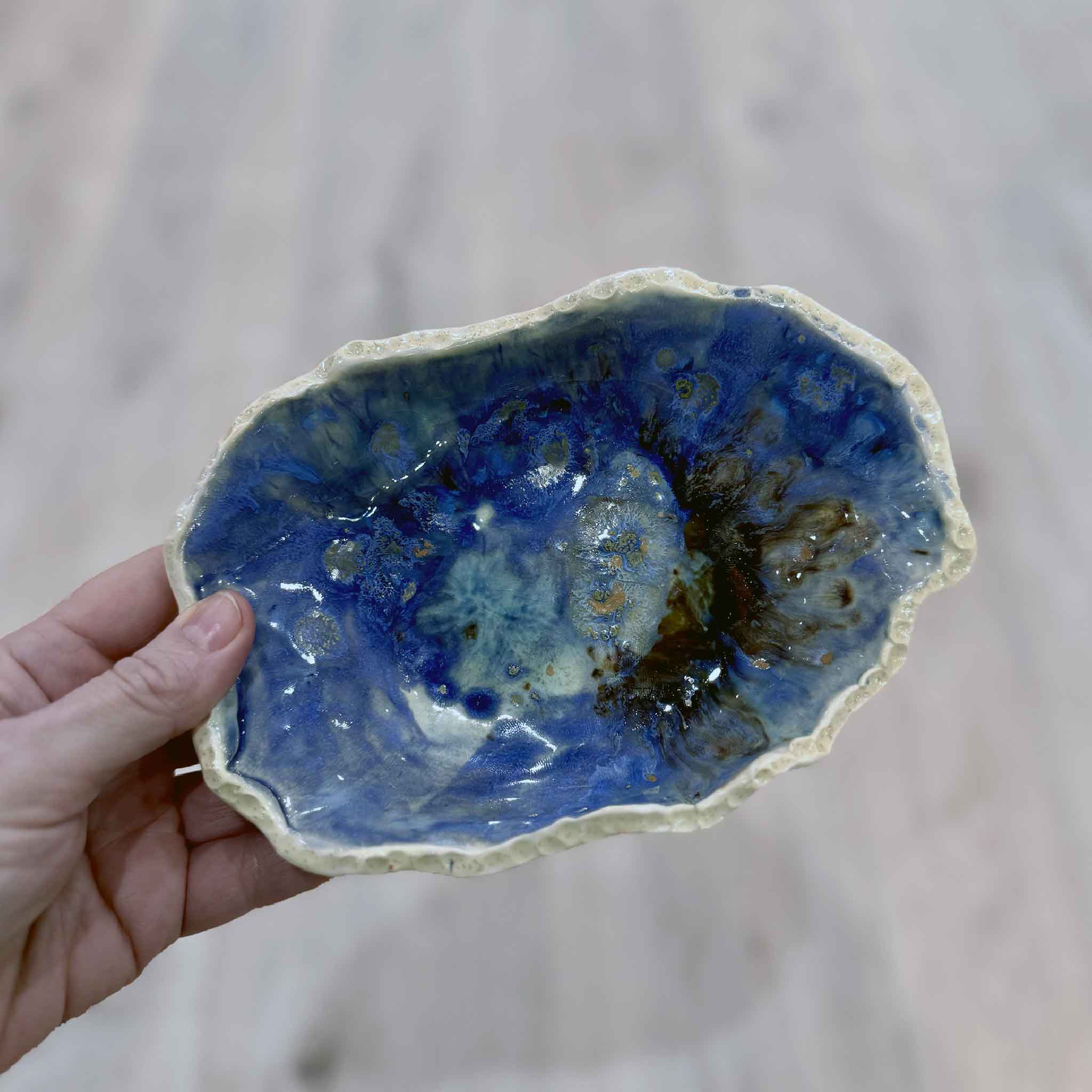 Medium deep blue Seaspray bowl with swirling maritime glaze by local artist Vida Miller, photographed for scale in Gray Man Gallery.