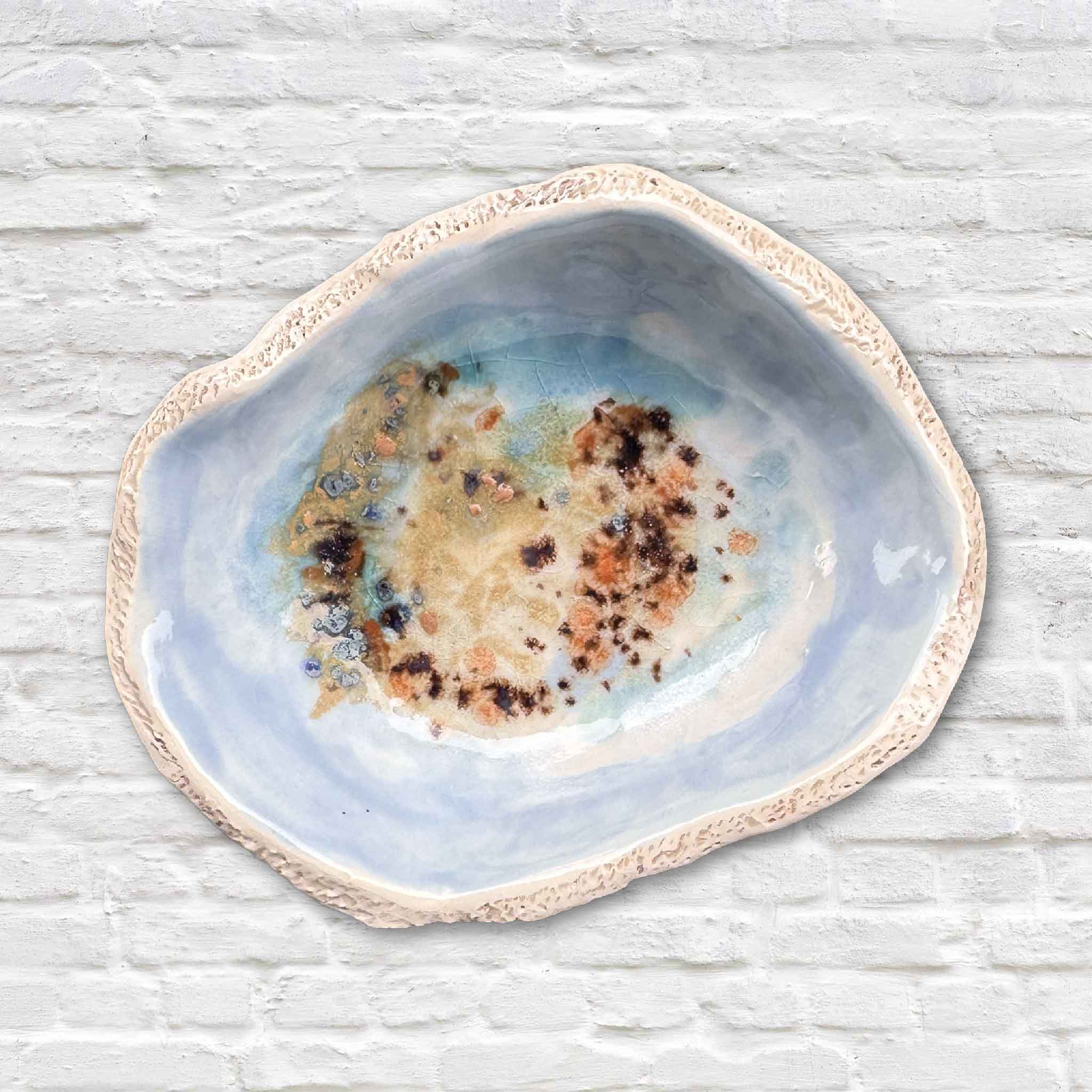 Small light blue Seaspray bowl with soft aqua and sandy glaze by local Lowcountry artist Vida Miller, photographed outdoors at Gray Man Gallery.