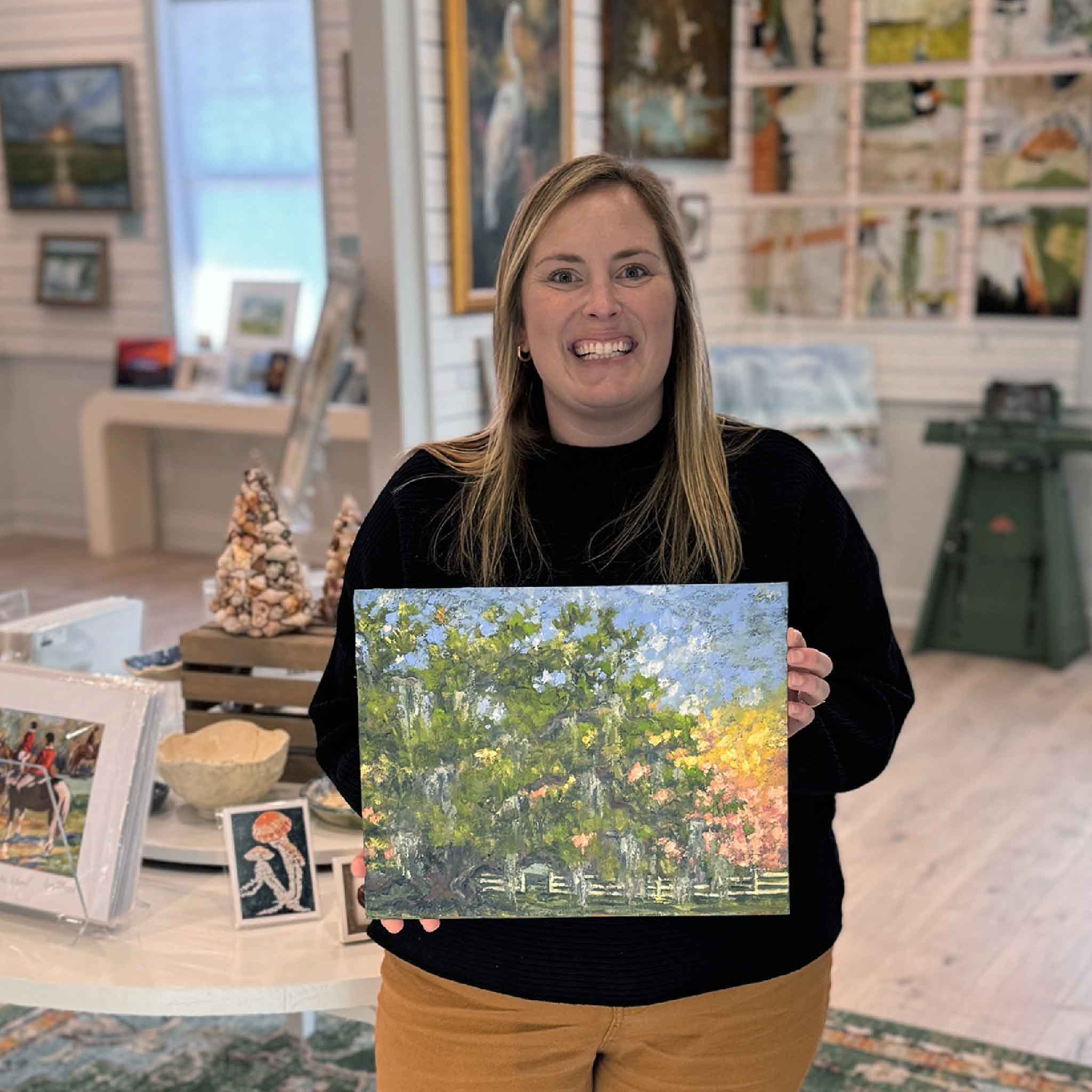 Staff member holding Waverly in Bloom, an original 14x11 oil painting on board by Jeanne O’Neal, showing scale and detail of the Lowcountry landscape artwork at Gray Man Gallery in Pawleys Island.