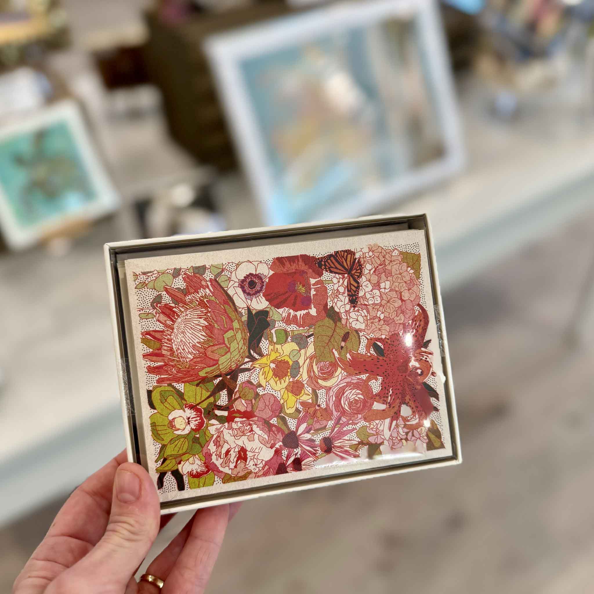 Wild Florals boxed notecard set by Caroline Clark held inside Gray Man Gallery in Pawleys Island, featuring richly detailed colorful flowers and botanical artwork on a set of eight blank cards.